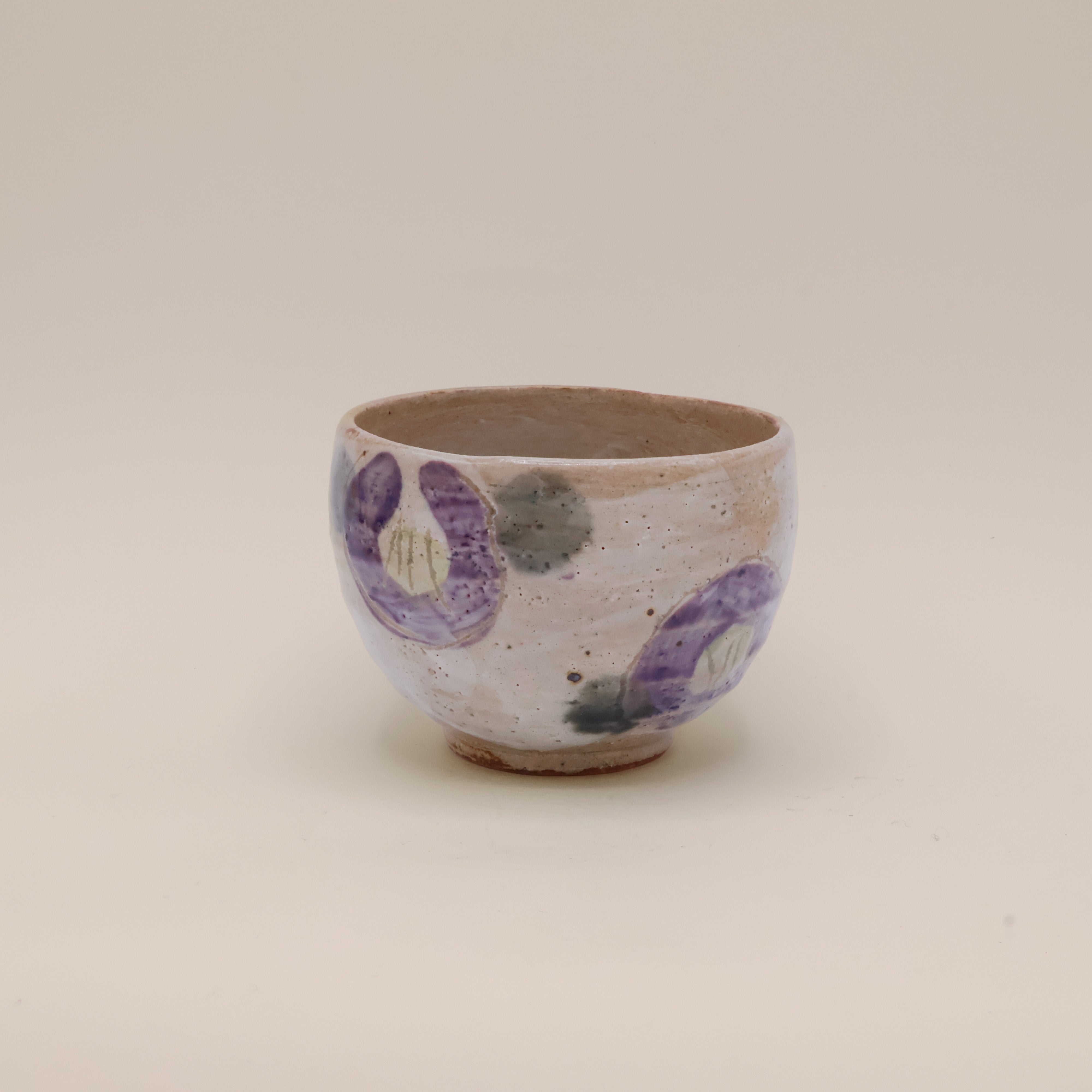 Kop med lilla blomster og grønne prikker