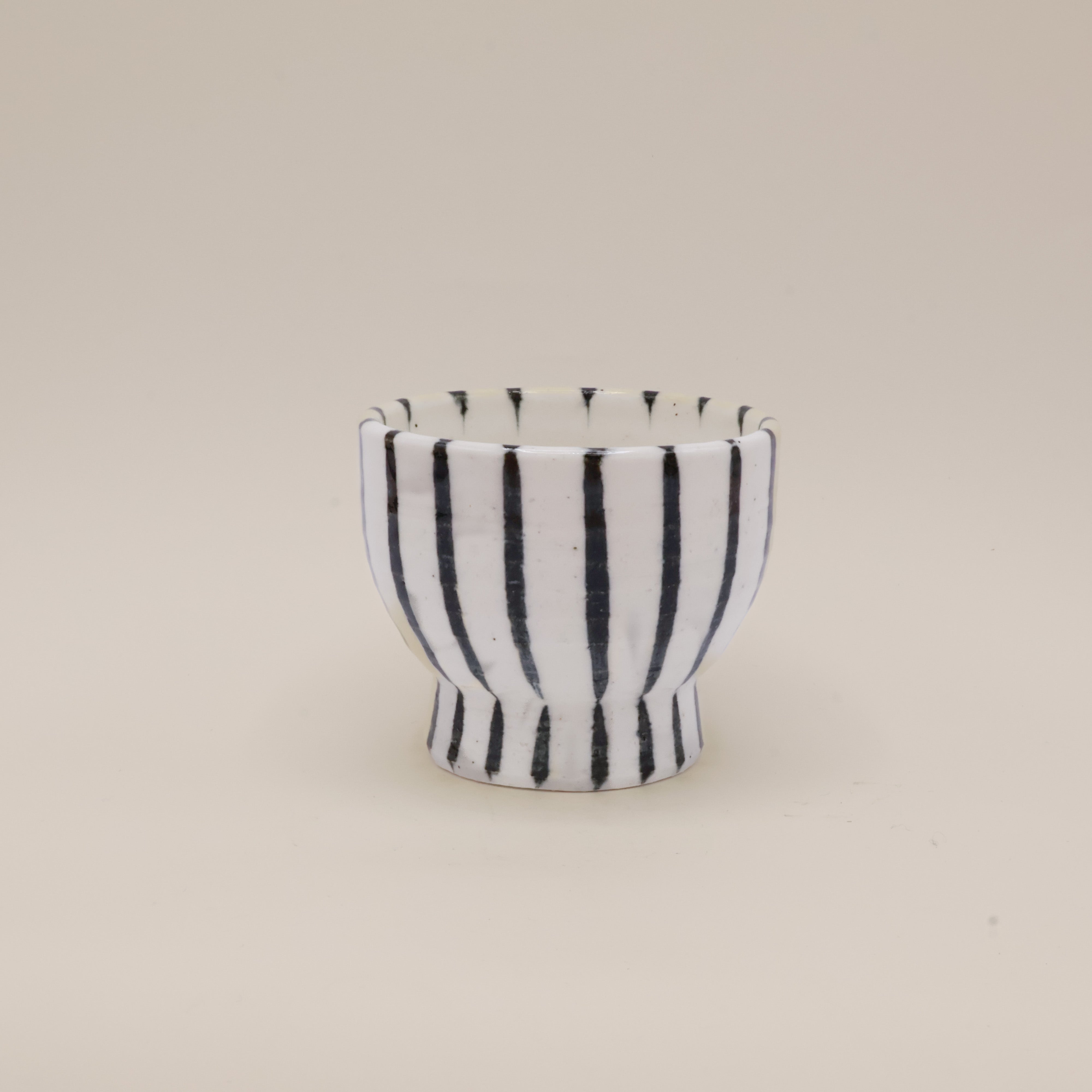 Hvid keramikkop på fod med mørkeblå striber