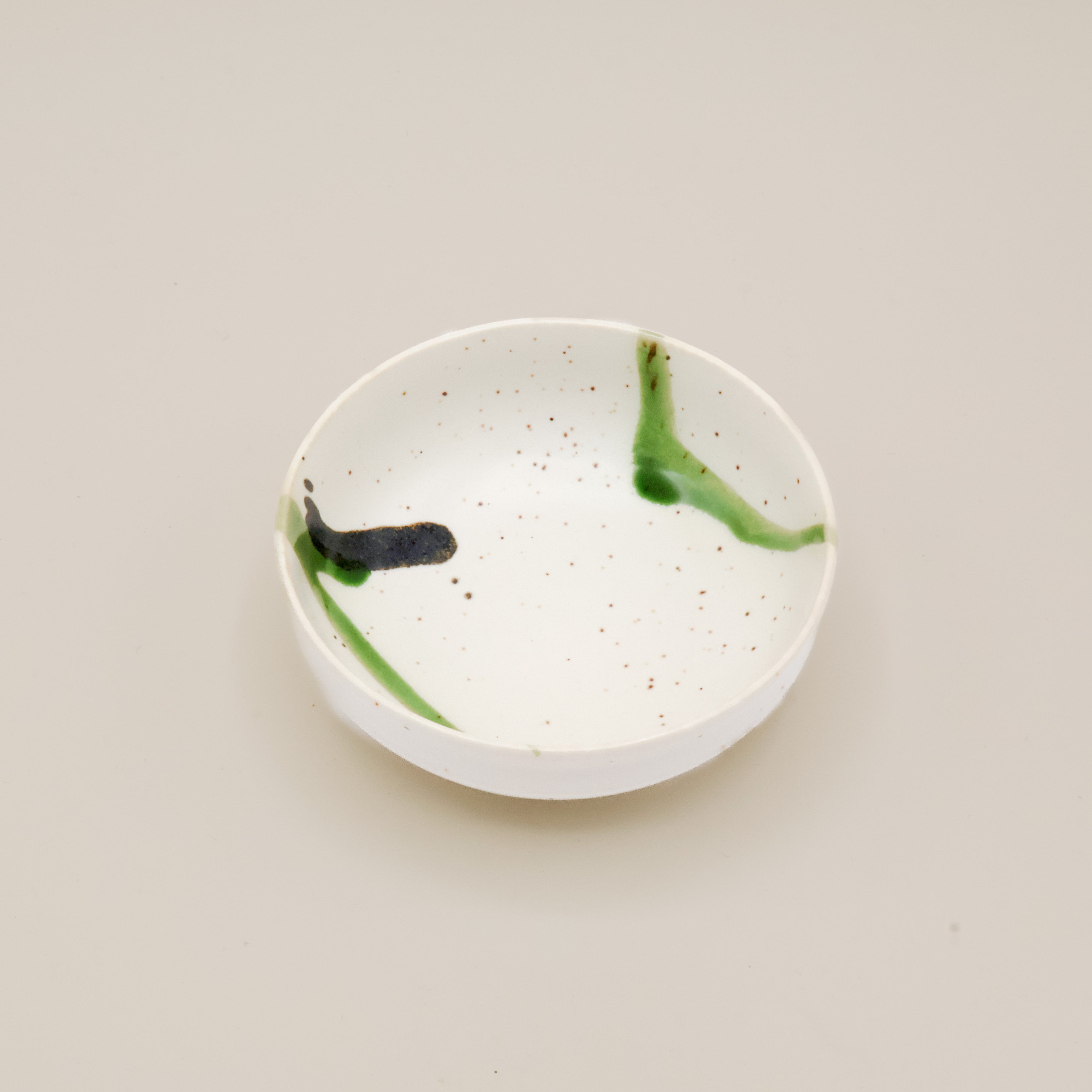 Lav skål med hvid glasur og grøn splash