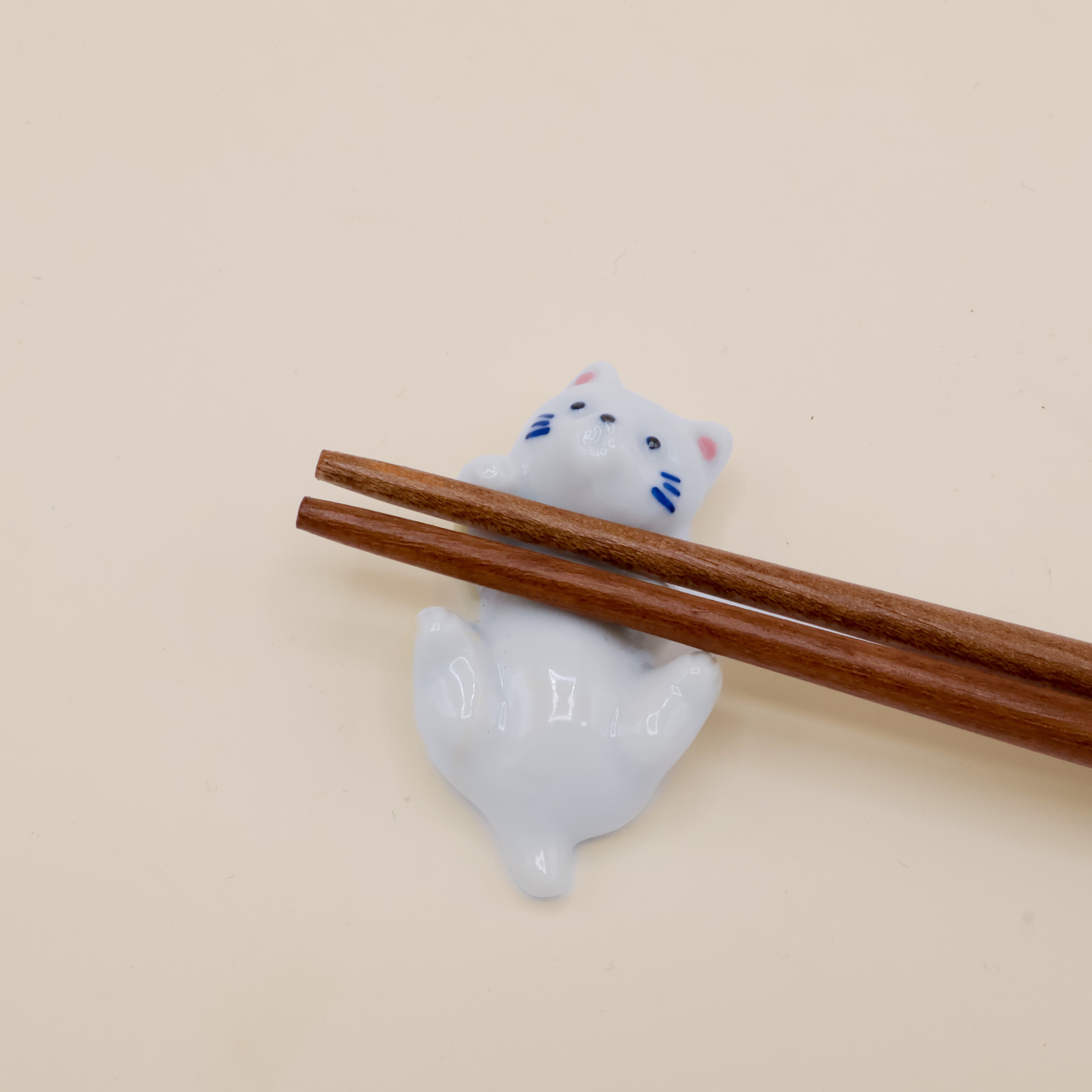 Spisepindeholder - Hvid kat der ligger på ryggen