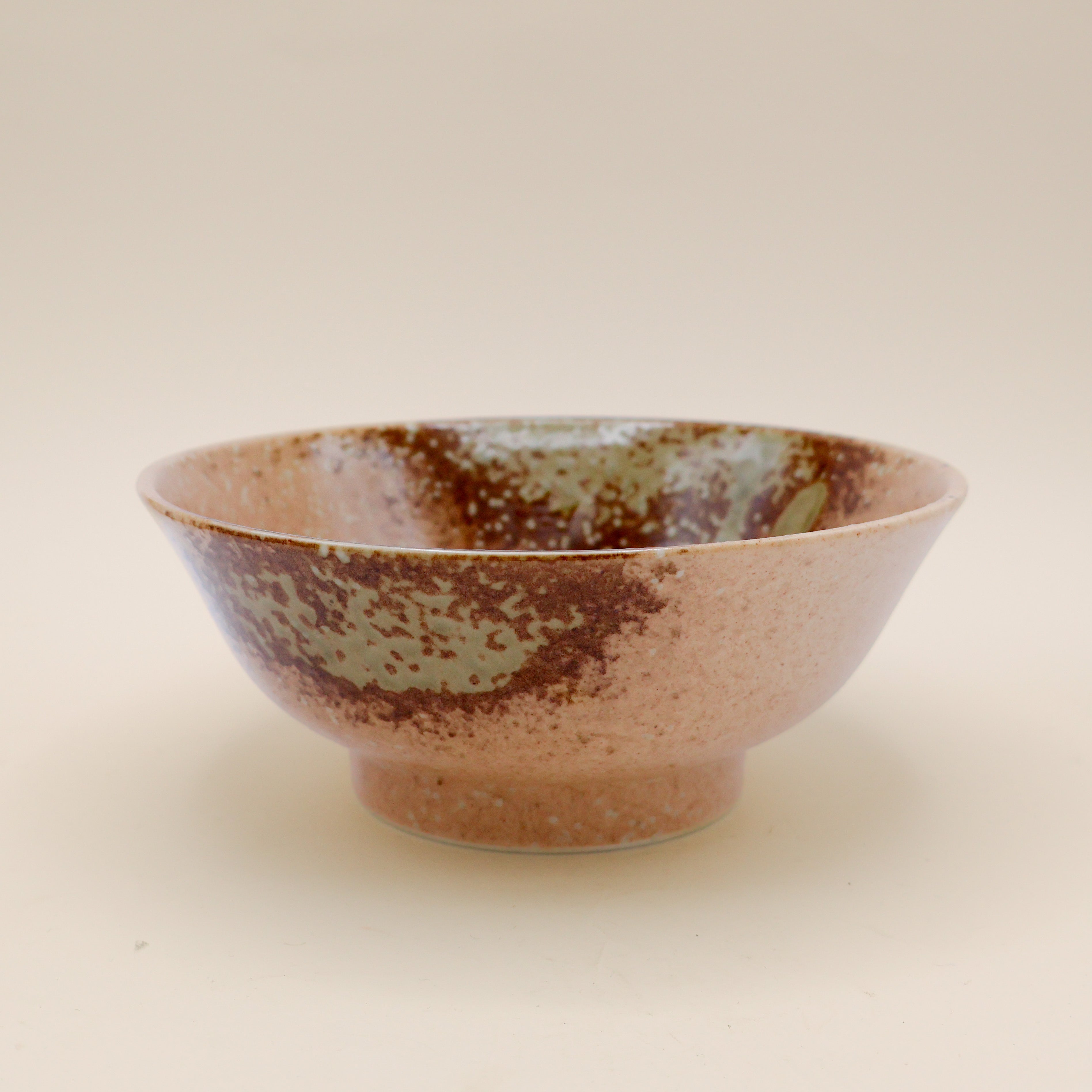 Ramen bowl in orange/brown with metallic detail and green splash