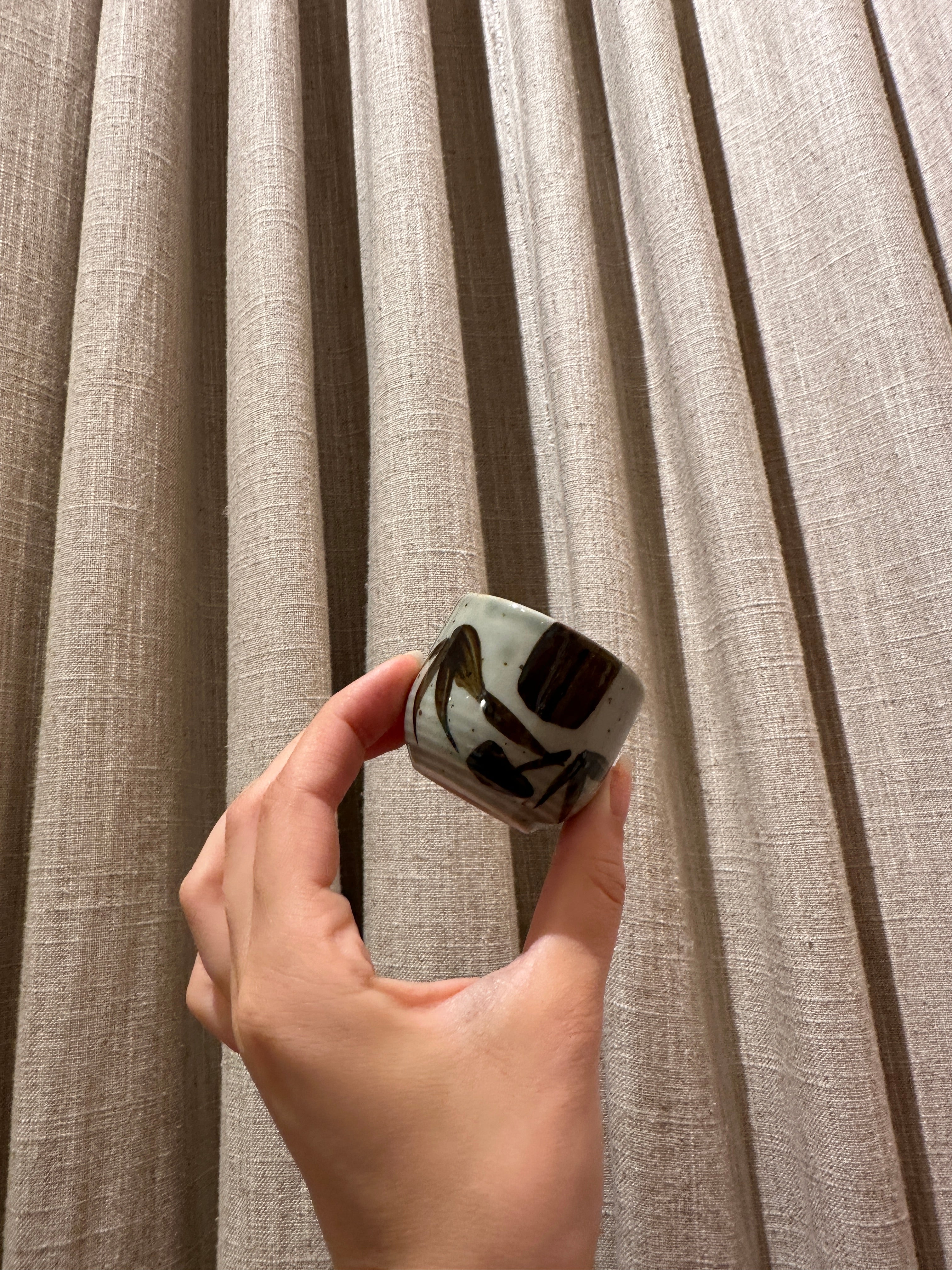 (missing price) Sake cup in greenish glaze with brown embers and bamboo leaves