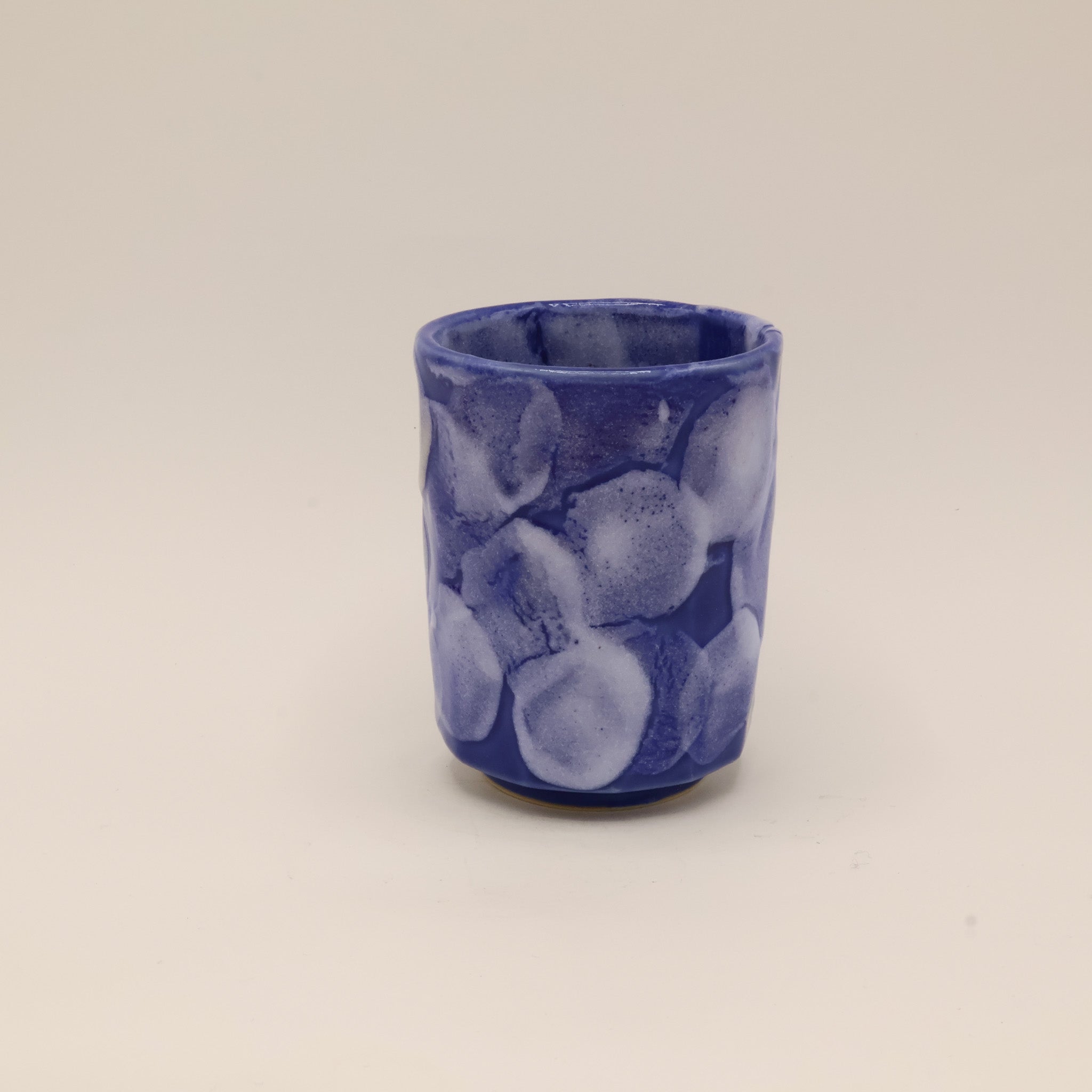 Keramikkop med blå glasur og hvide detaljer