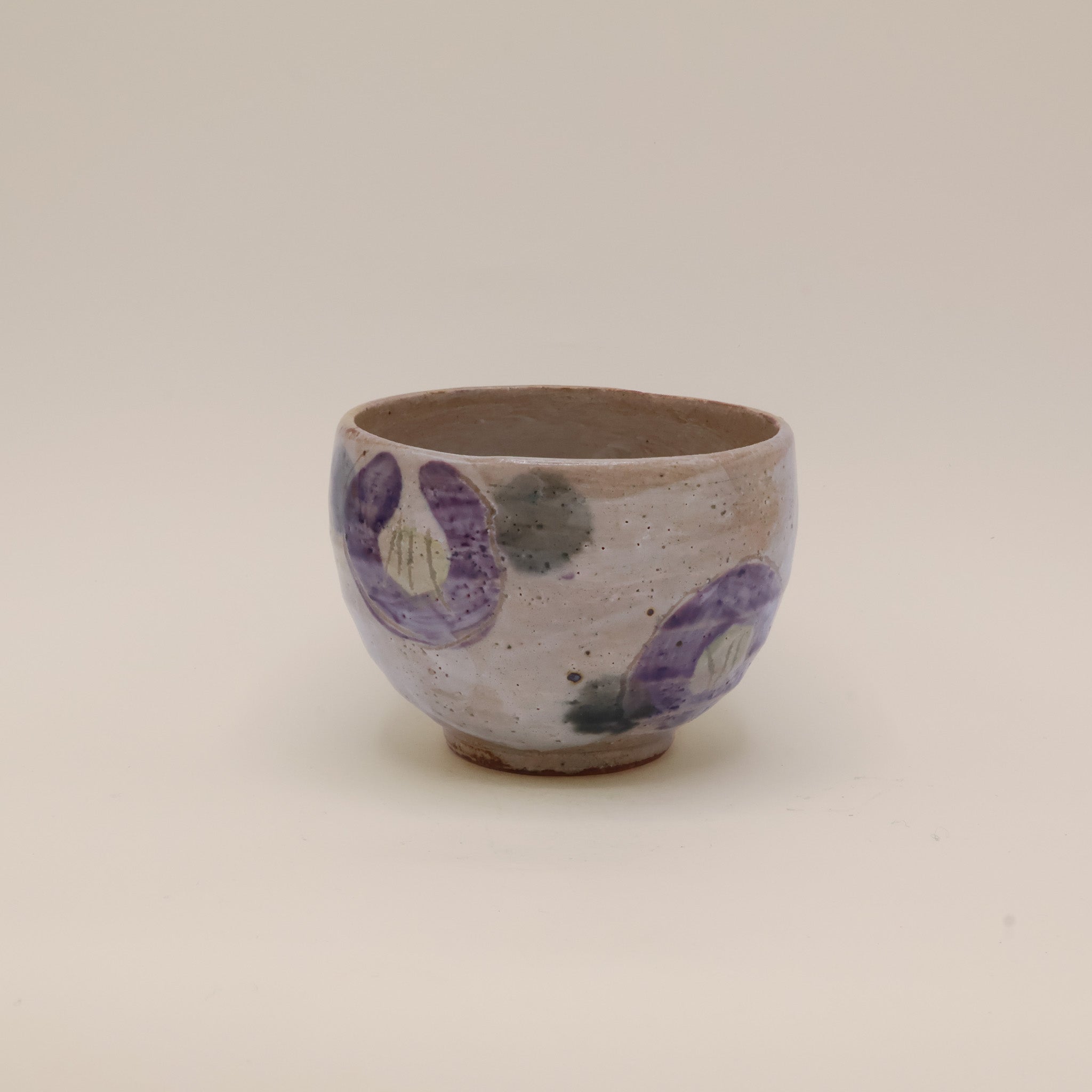 Kop med lilla blomster og grønne prikker