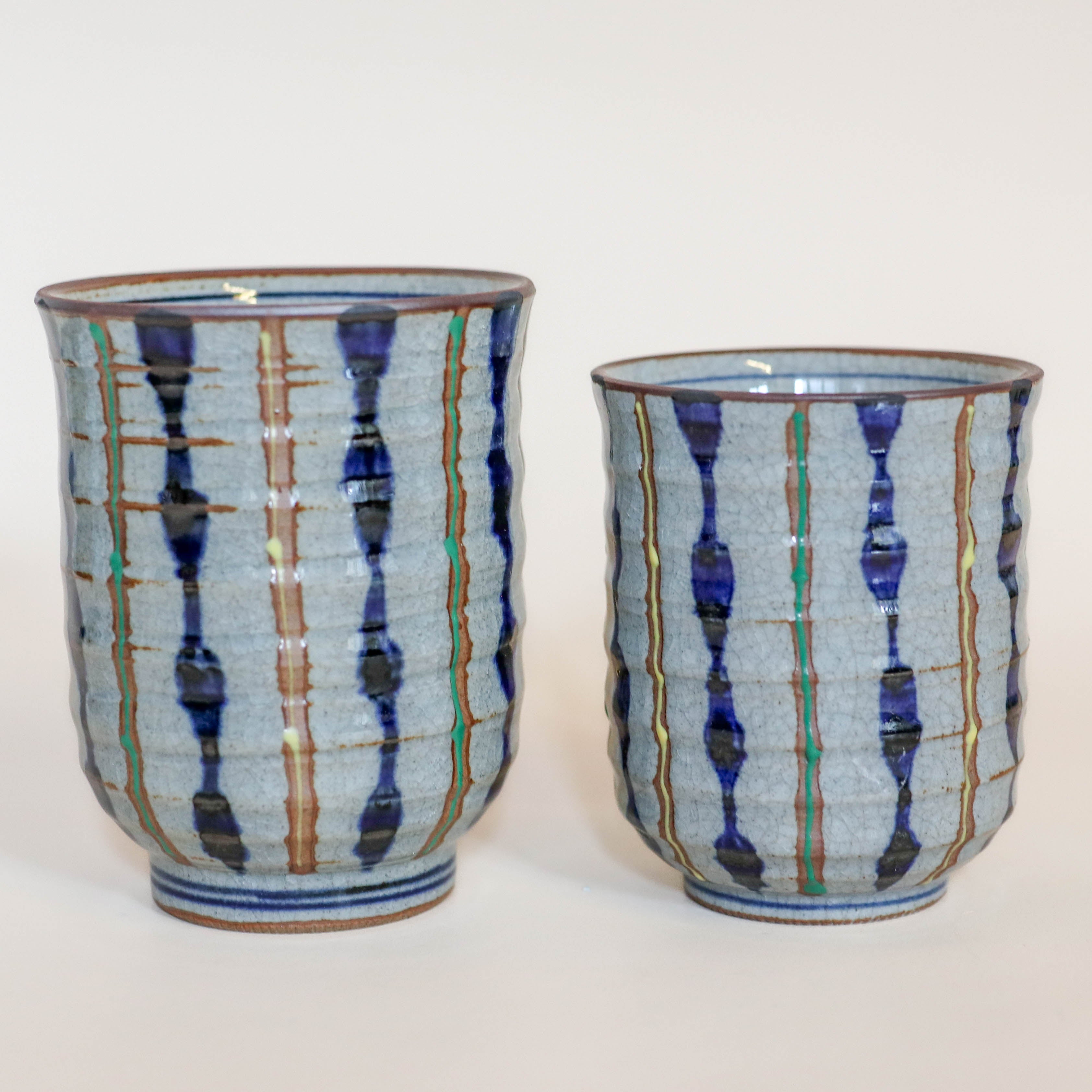 Grå kop med blå, gule og grønne striber