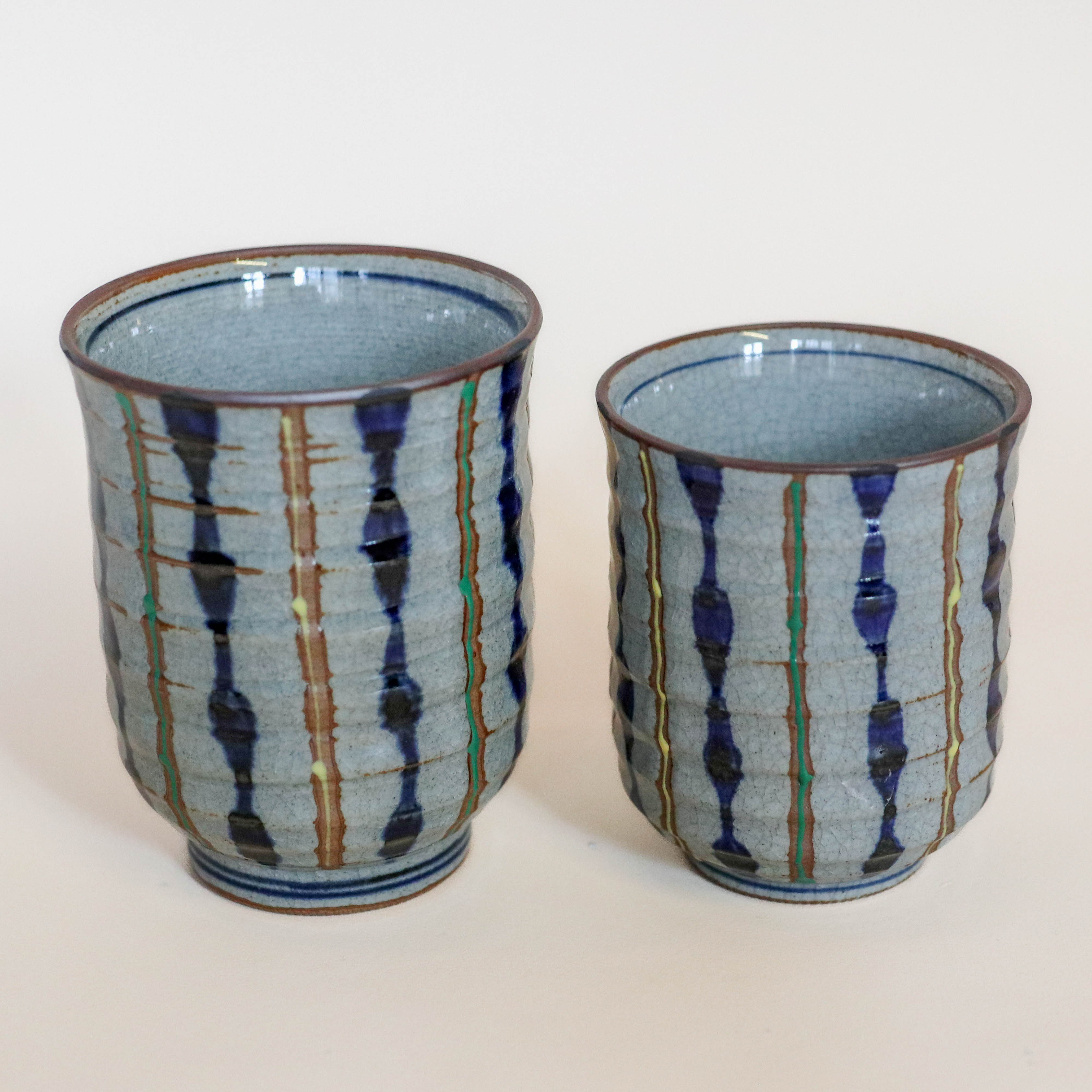 Grå kop med blå, gule og grønne striber