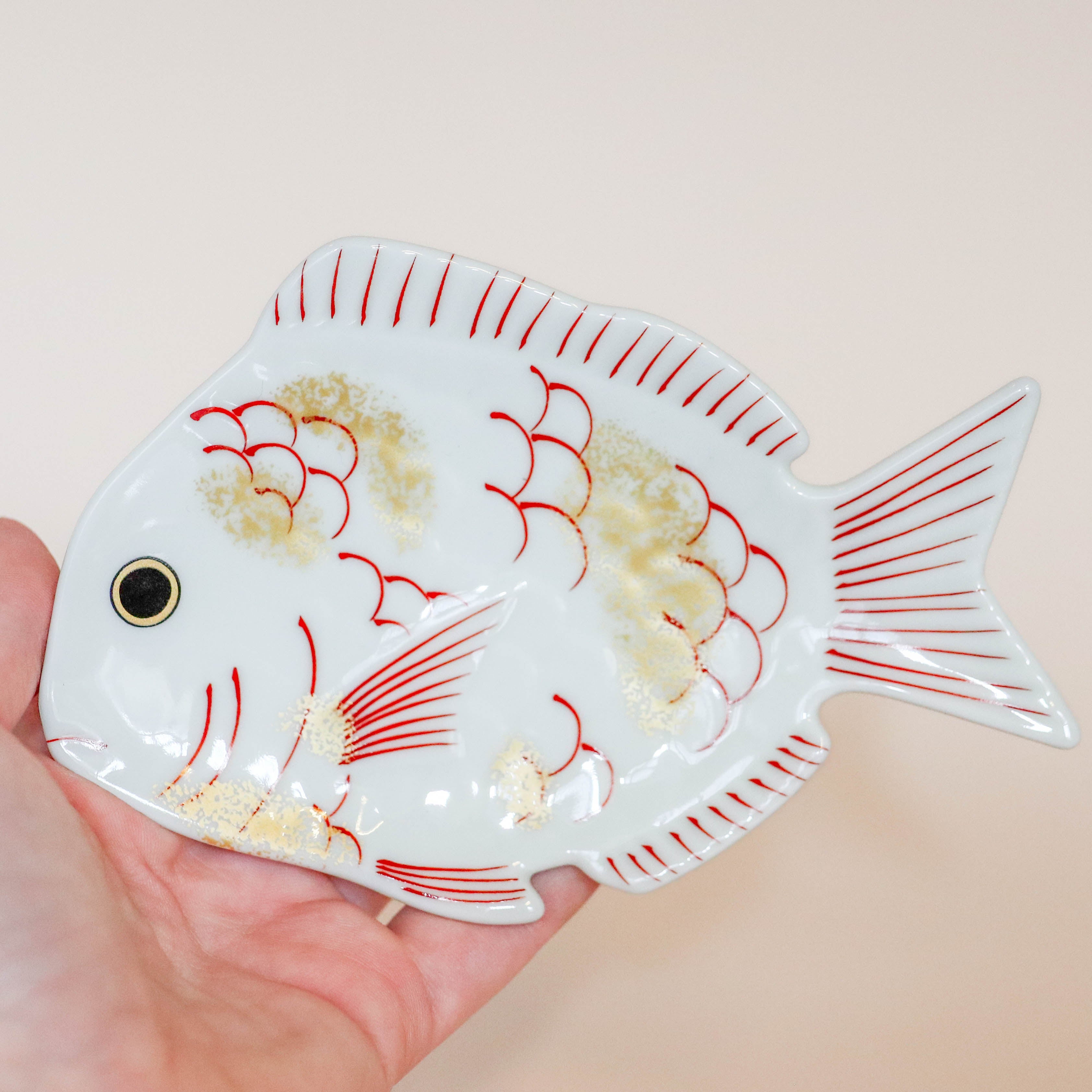 Tallerken formet som fisk med gulddetaljer