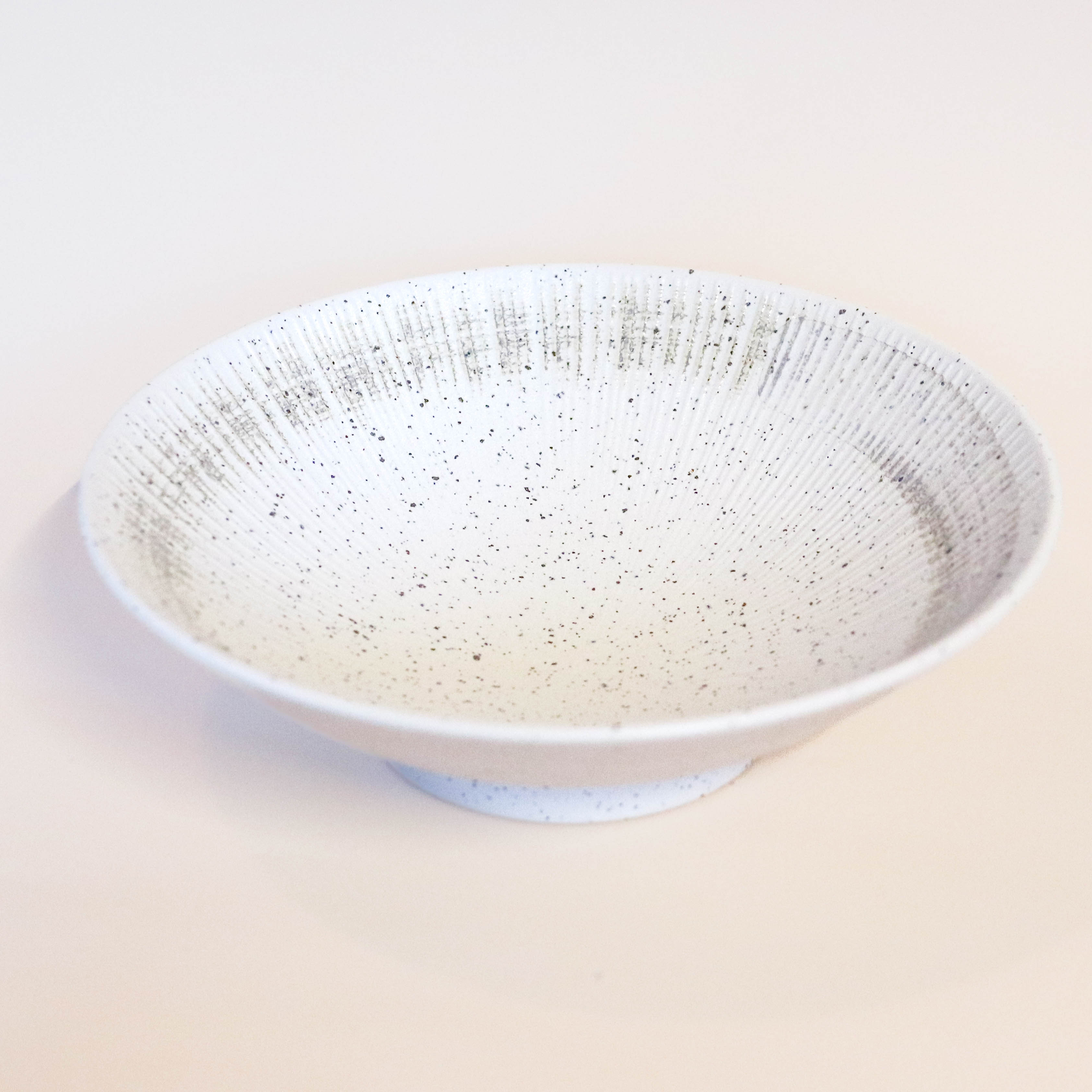 Hvid skål med brune nister og børstet detaljer