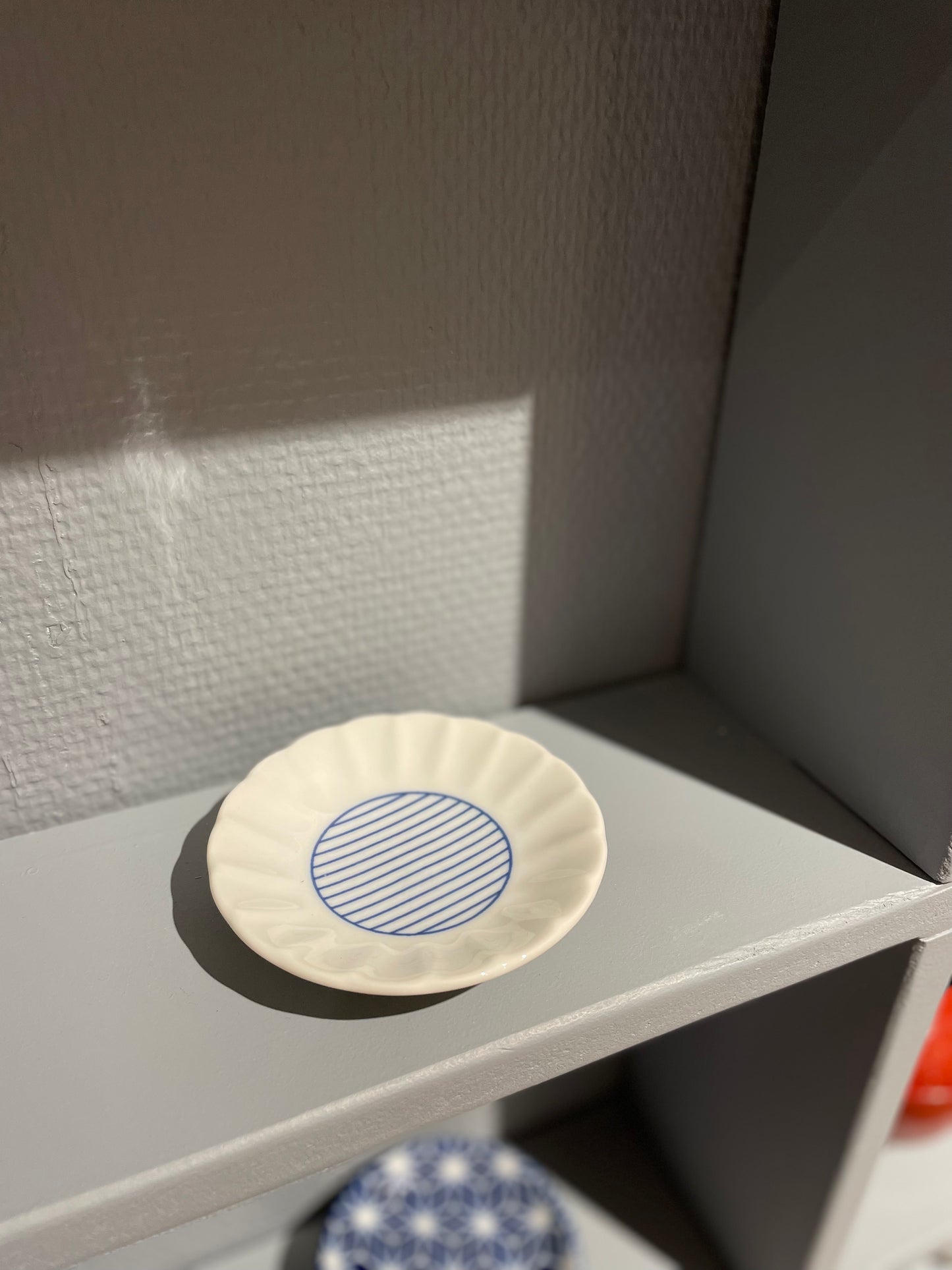 Lille hvid tallerken med blå striber i midten