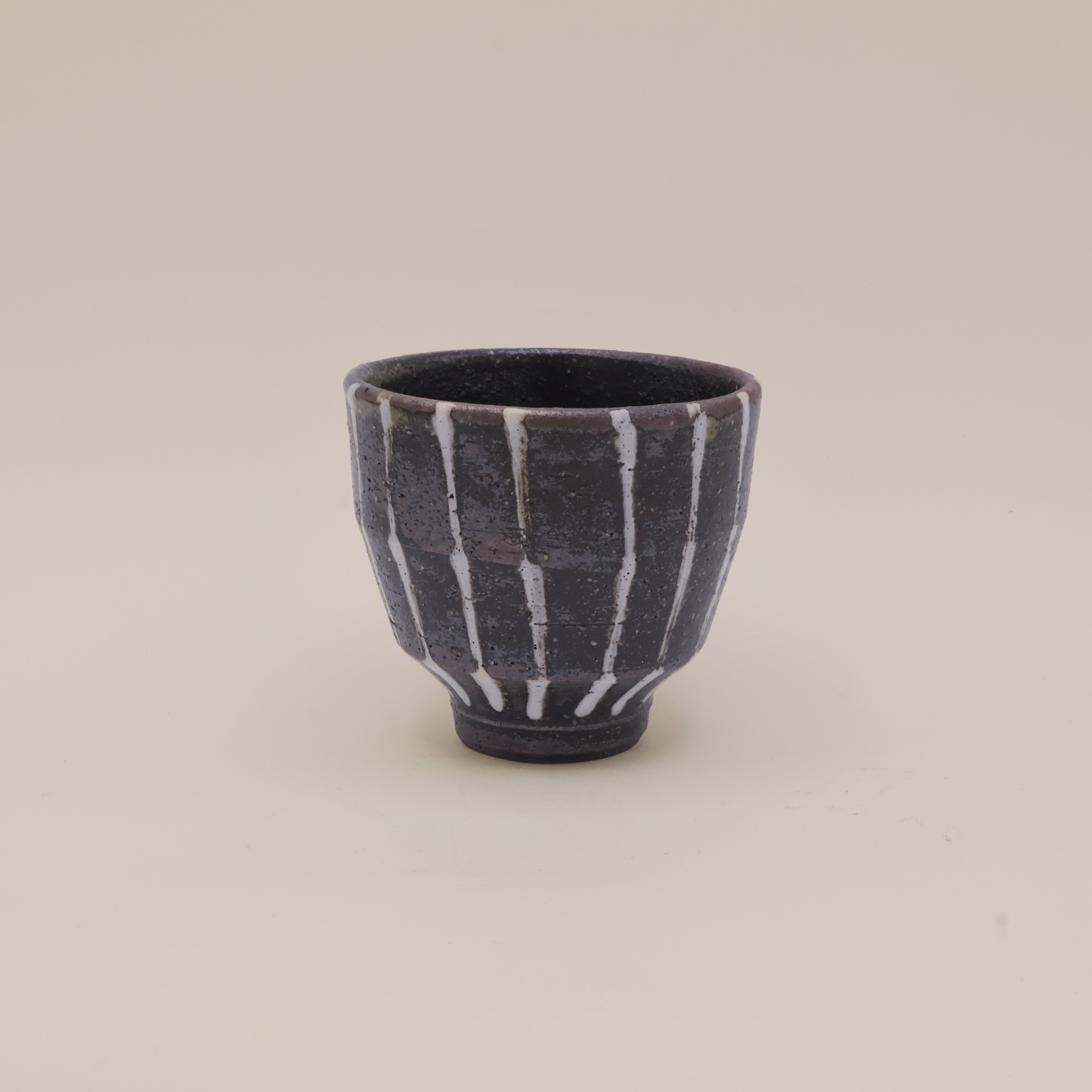 Brown ceramic cup with white stripes