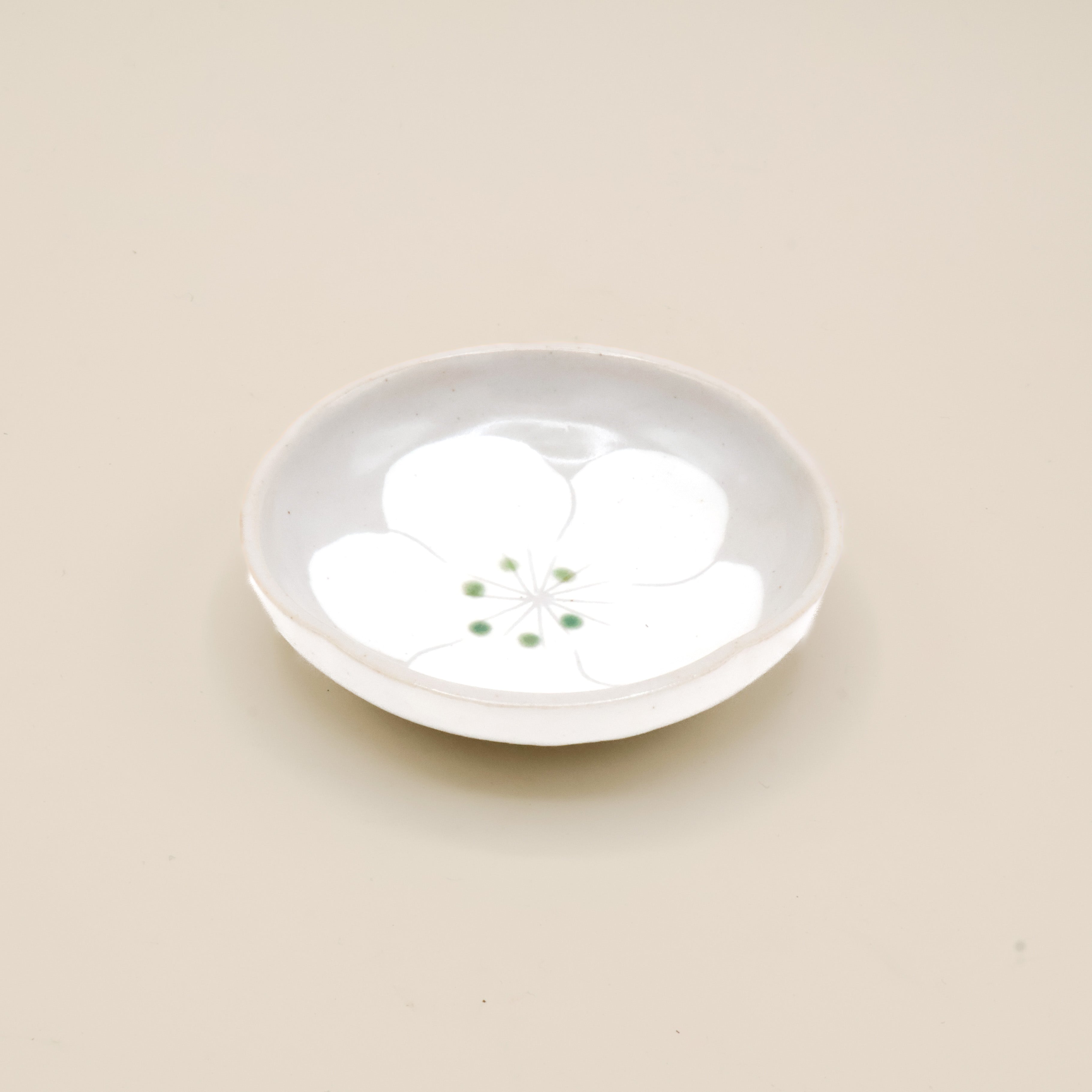 Lille grå skål med hvid blomst og grønne prikker