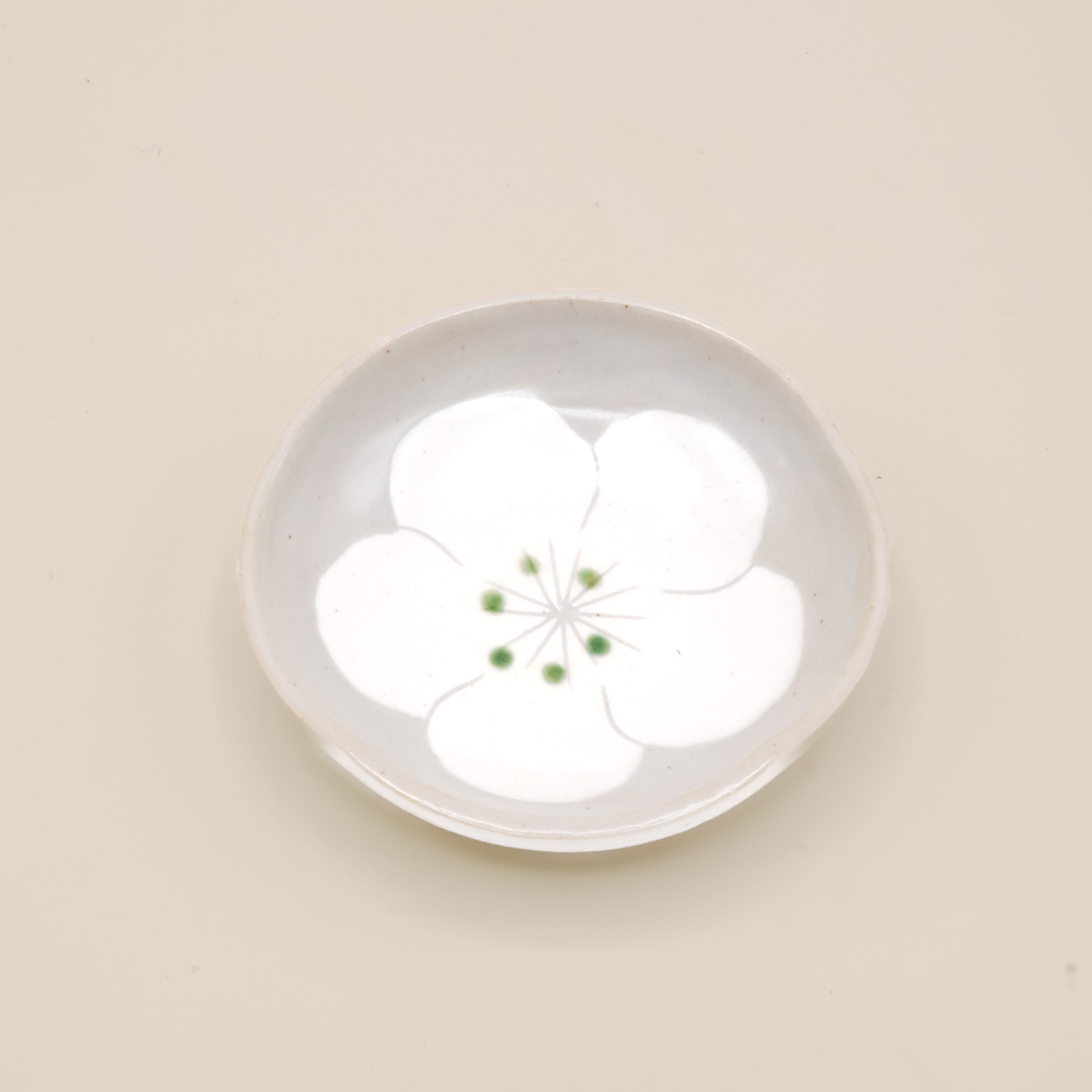 Lille grå skål med hvid blomst og grønne prikker