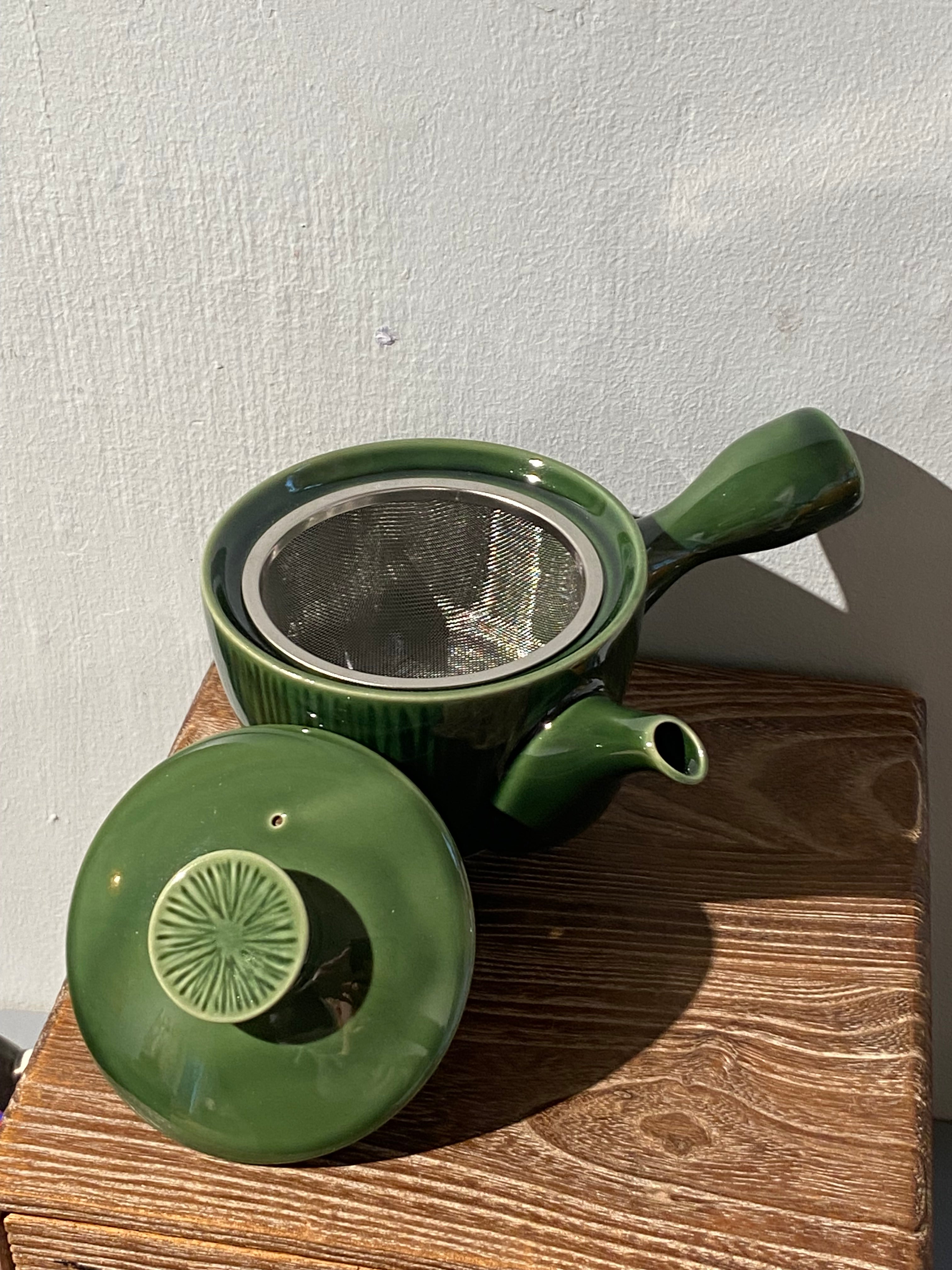 Glossy green teapot with handle