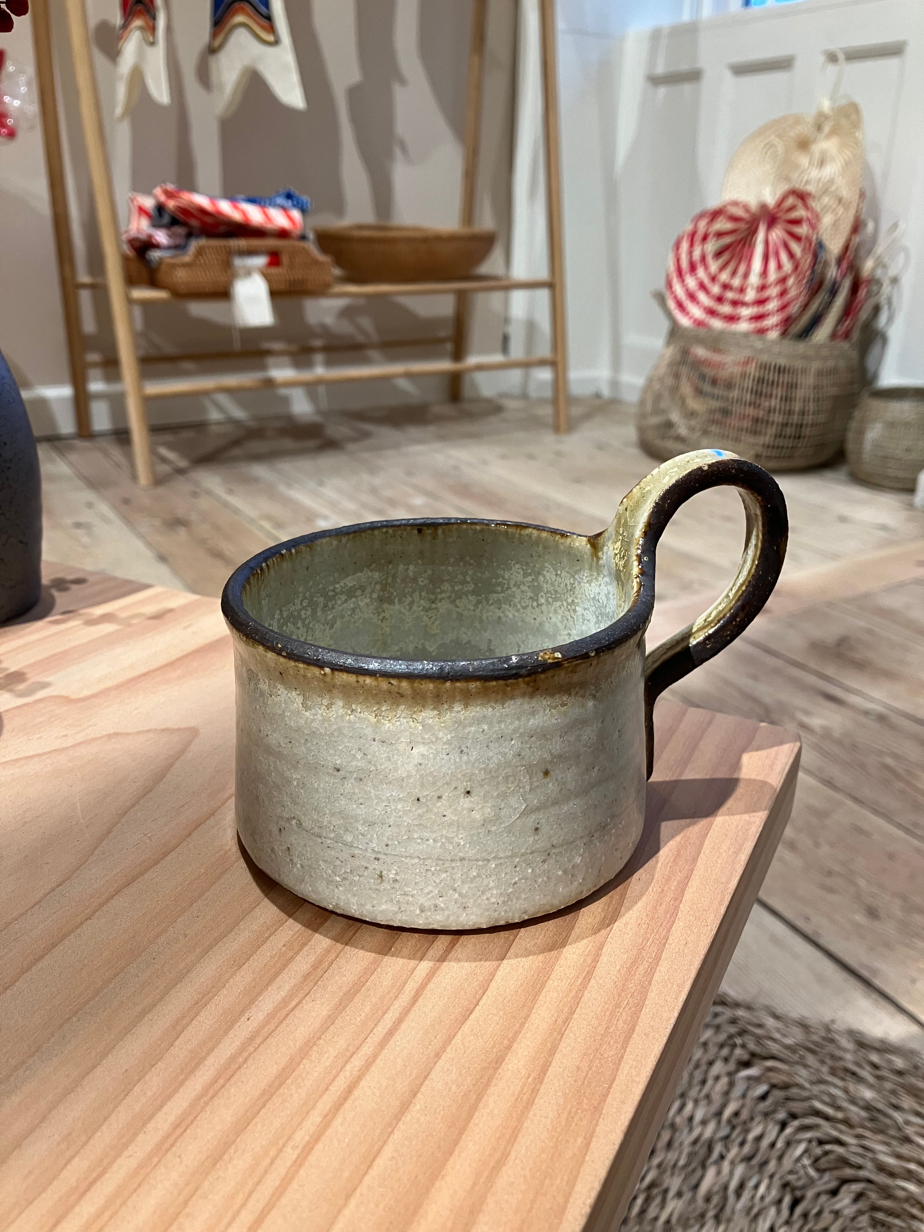 Rustic cup with brown rim and handle