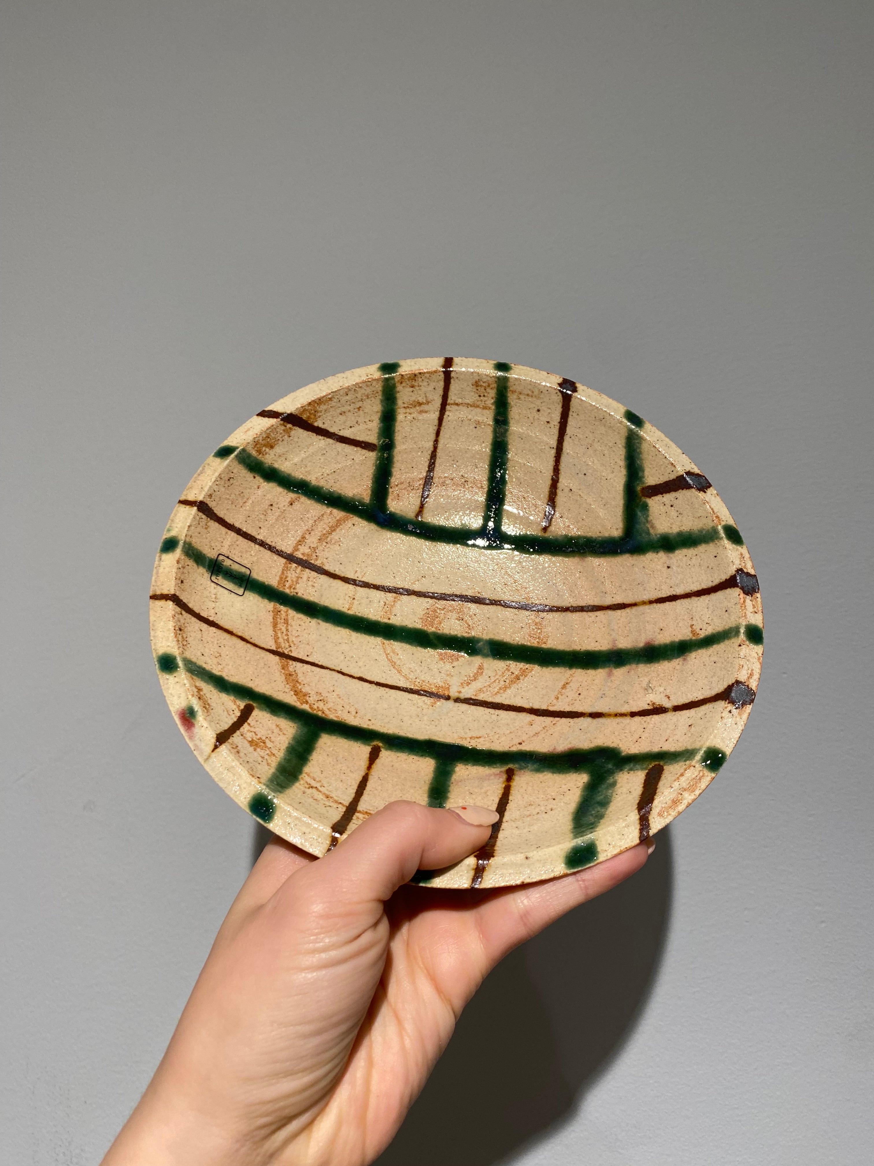 Flat bowl with green and brown line pattern