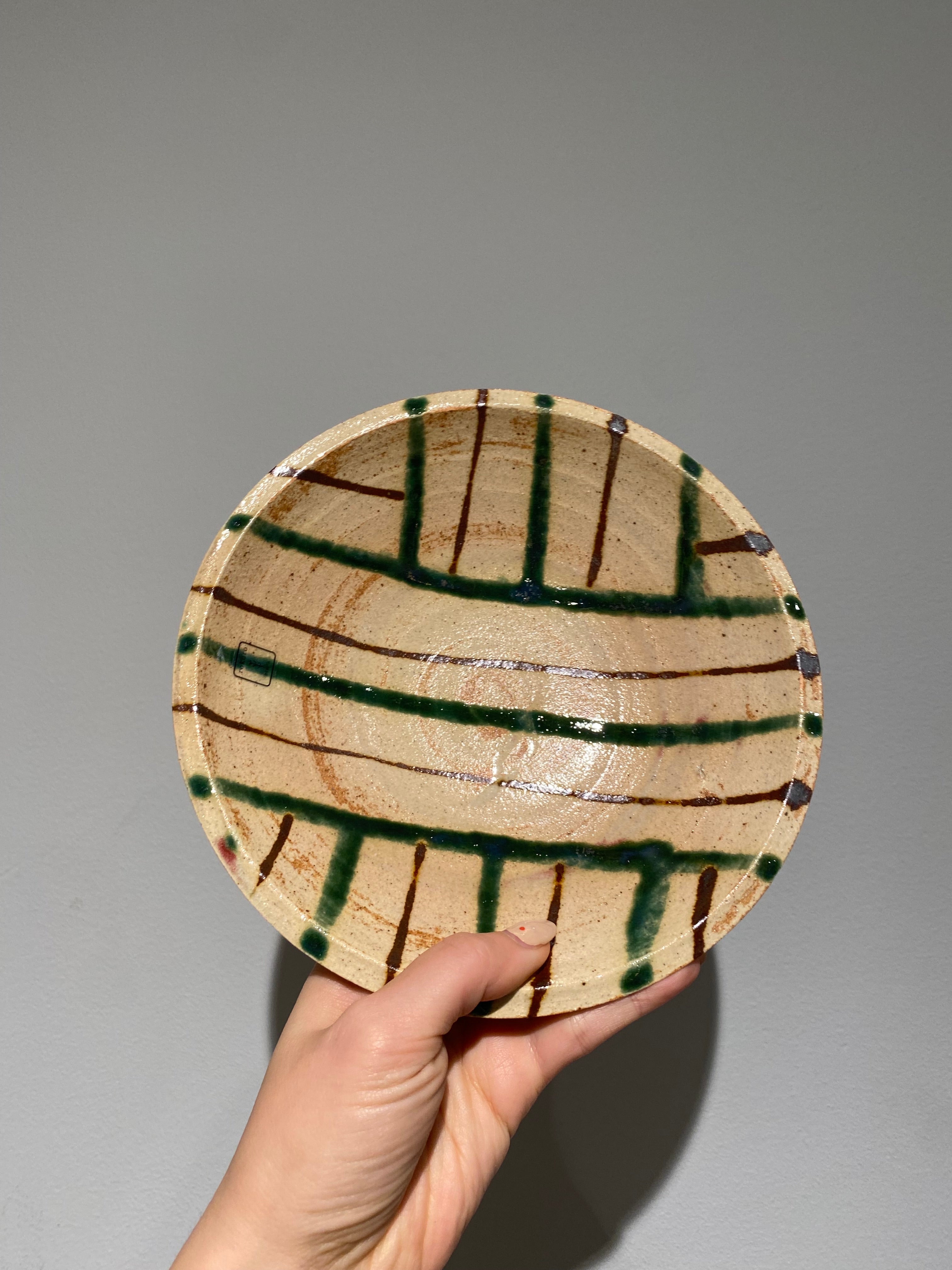 Flat bowl with green and brown line pattern