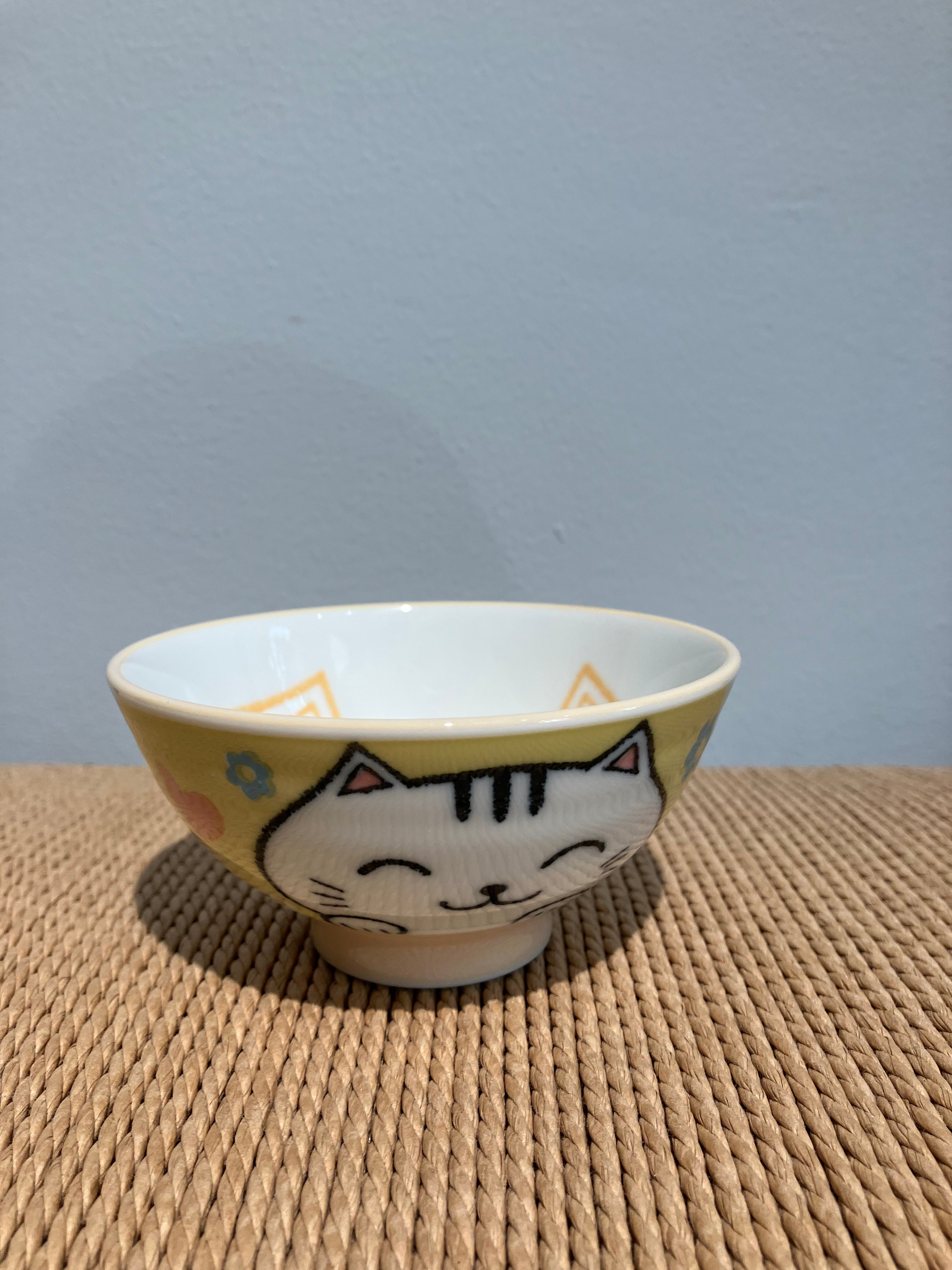 Yellow bowl with cat motif inside and outside