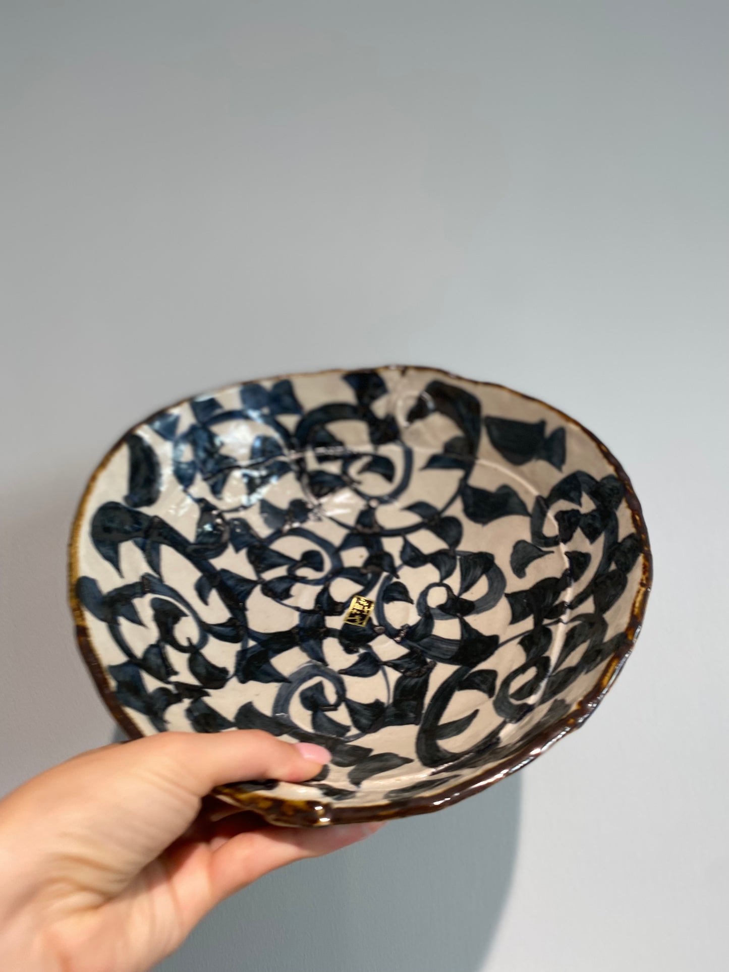 Stor skål med hvid glasur og mørkeblåt mønster og brun kant