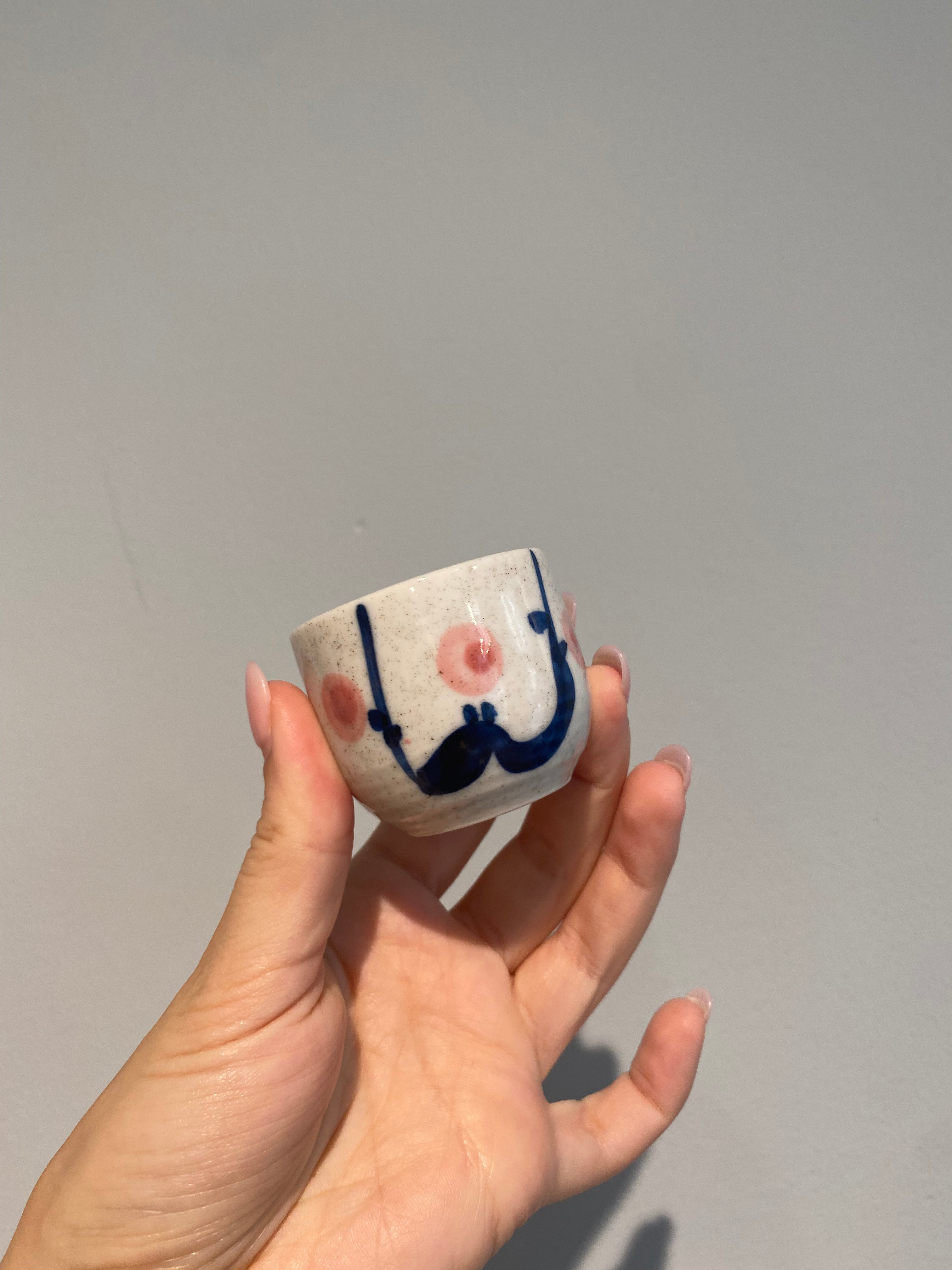 Sake cup with white glaze and flowers in blue and pink