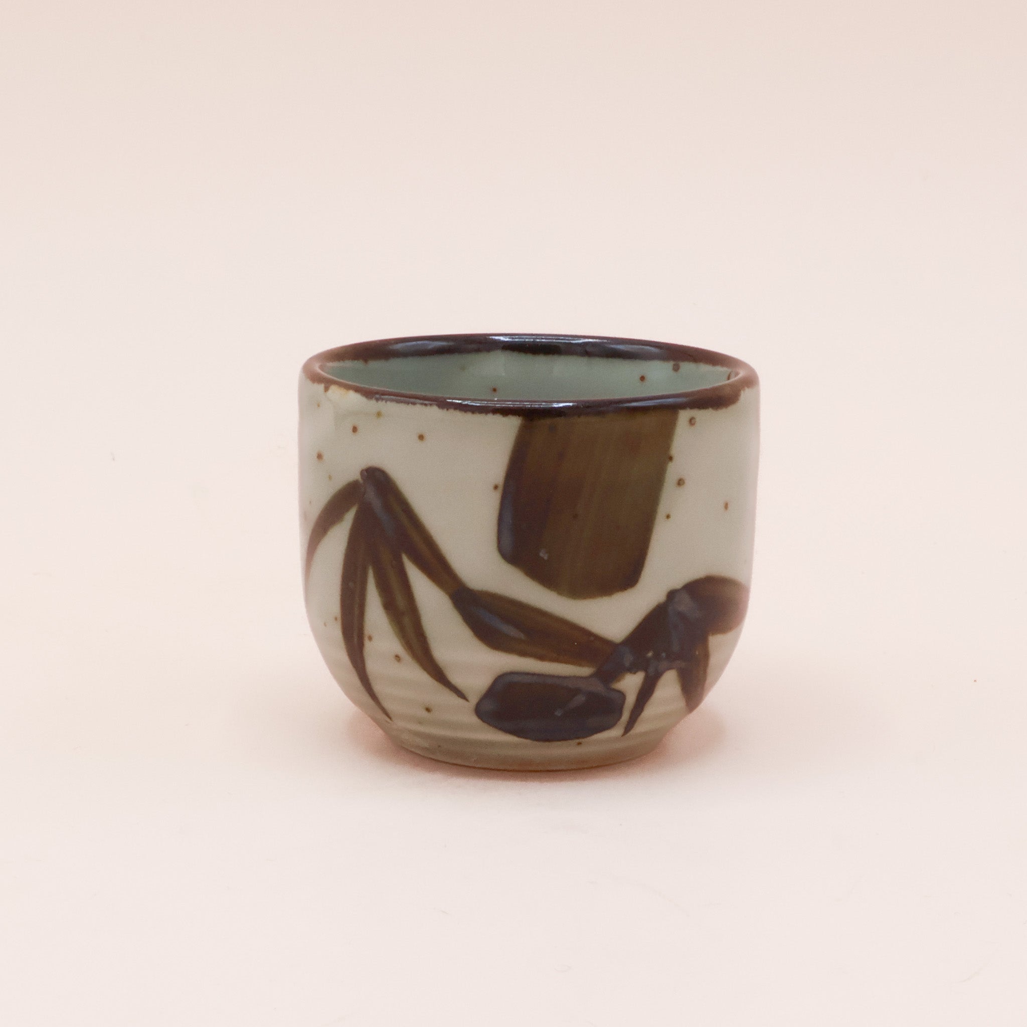 (missing price) Sake cup in greenish glaze with brown embers and bamboo leaves