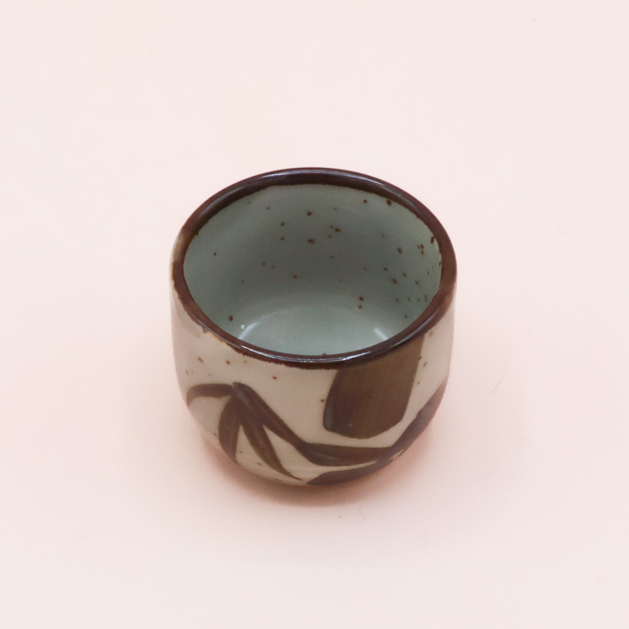 (missing price) Sake cup in greenish glaze with brown embers and bamboo leaves