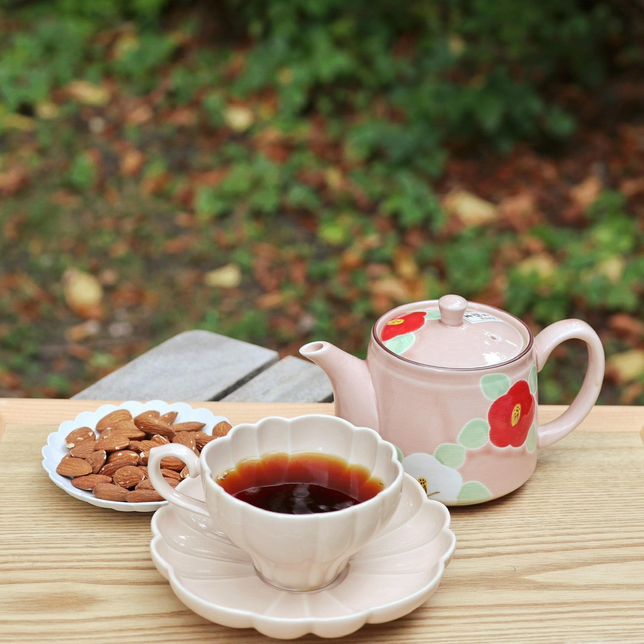 Lyserød tekande med røde blomster