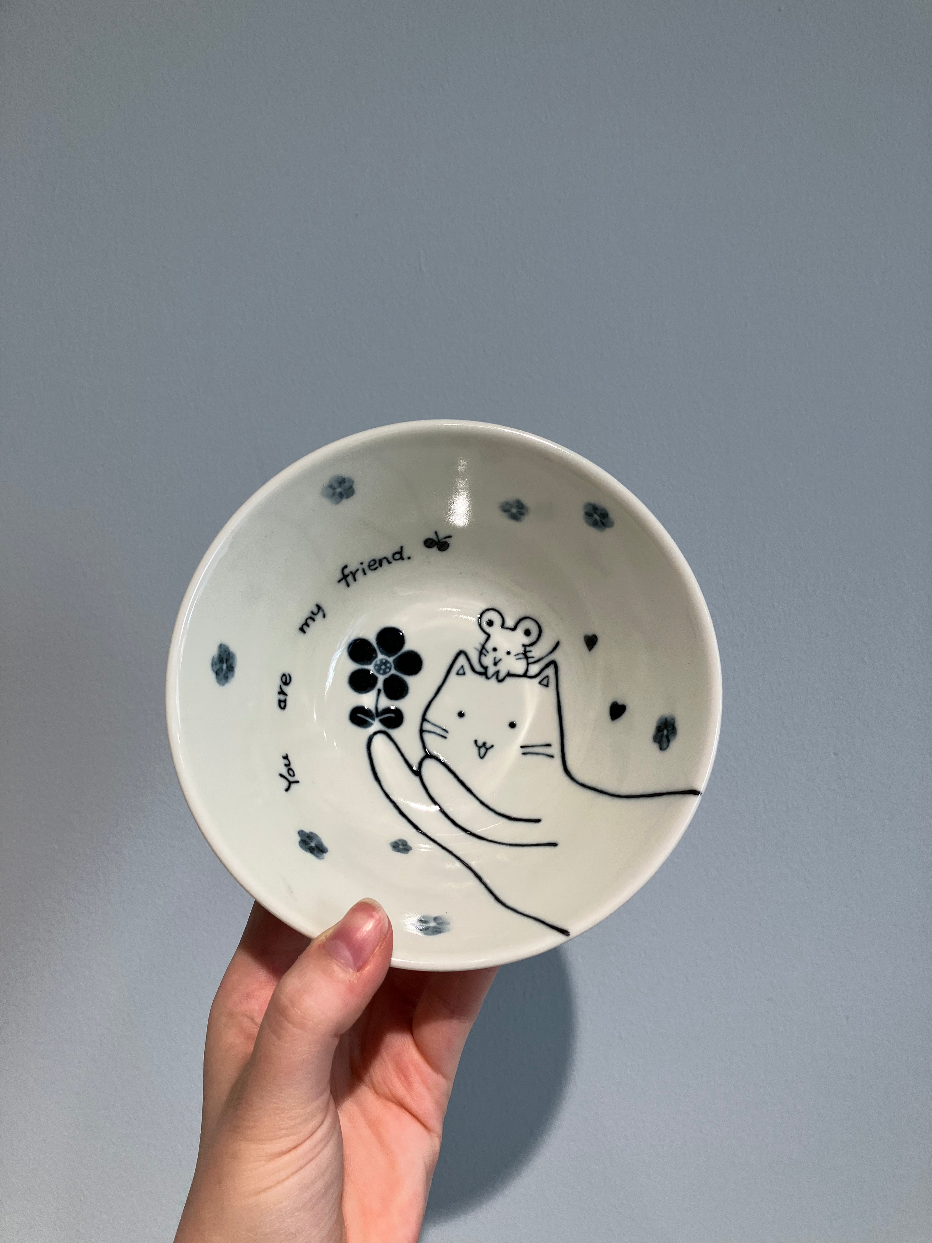 Bowl with a cat with a mouse on its head