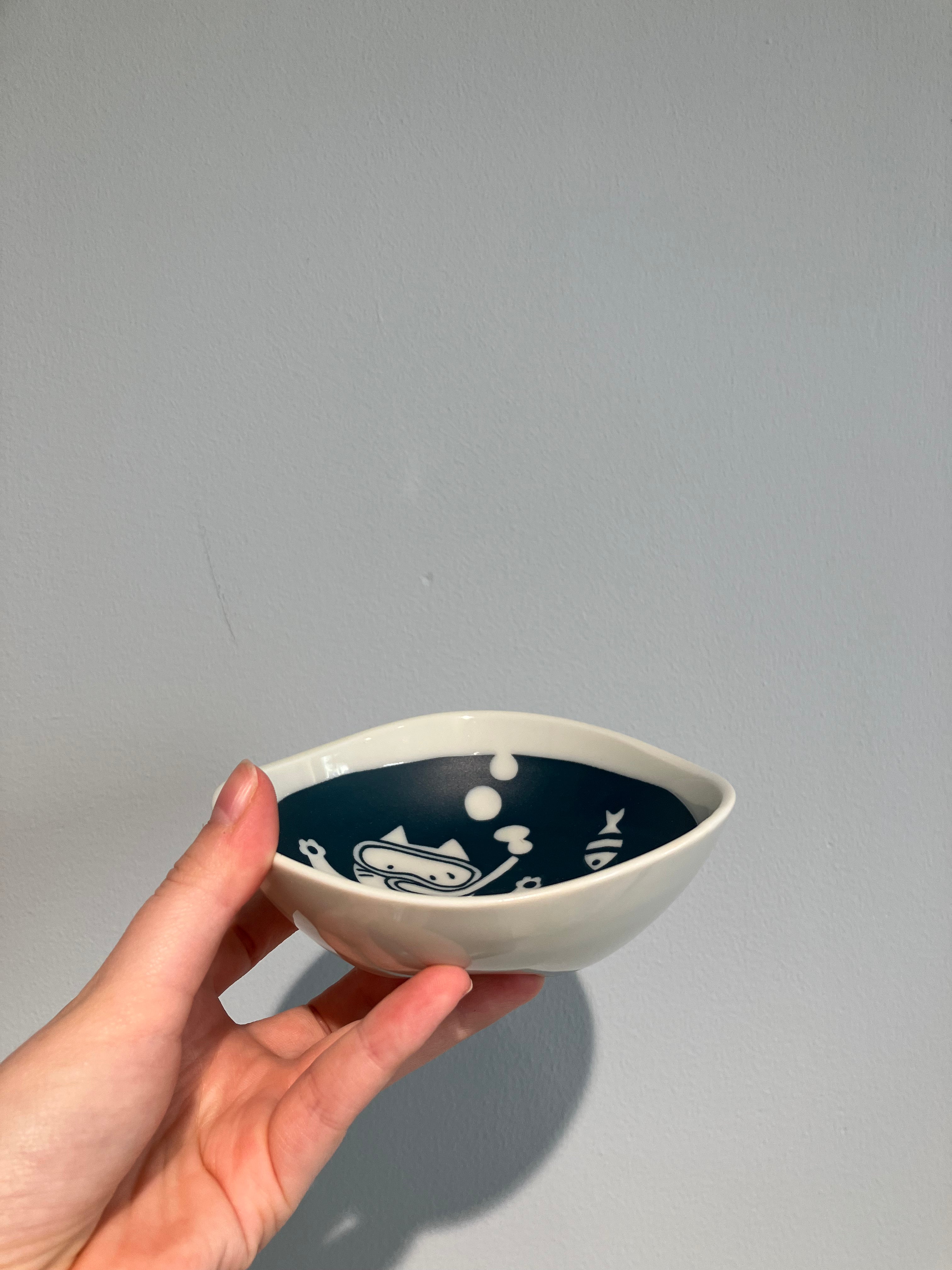 Bowl with cat diving