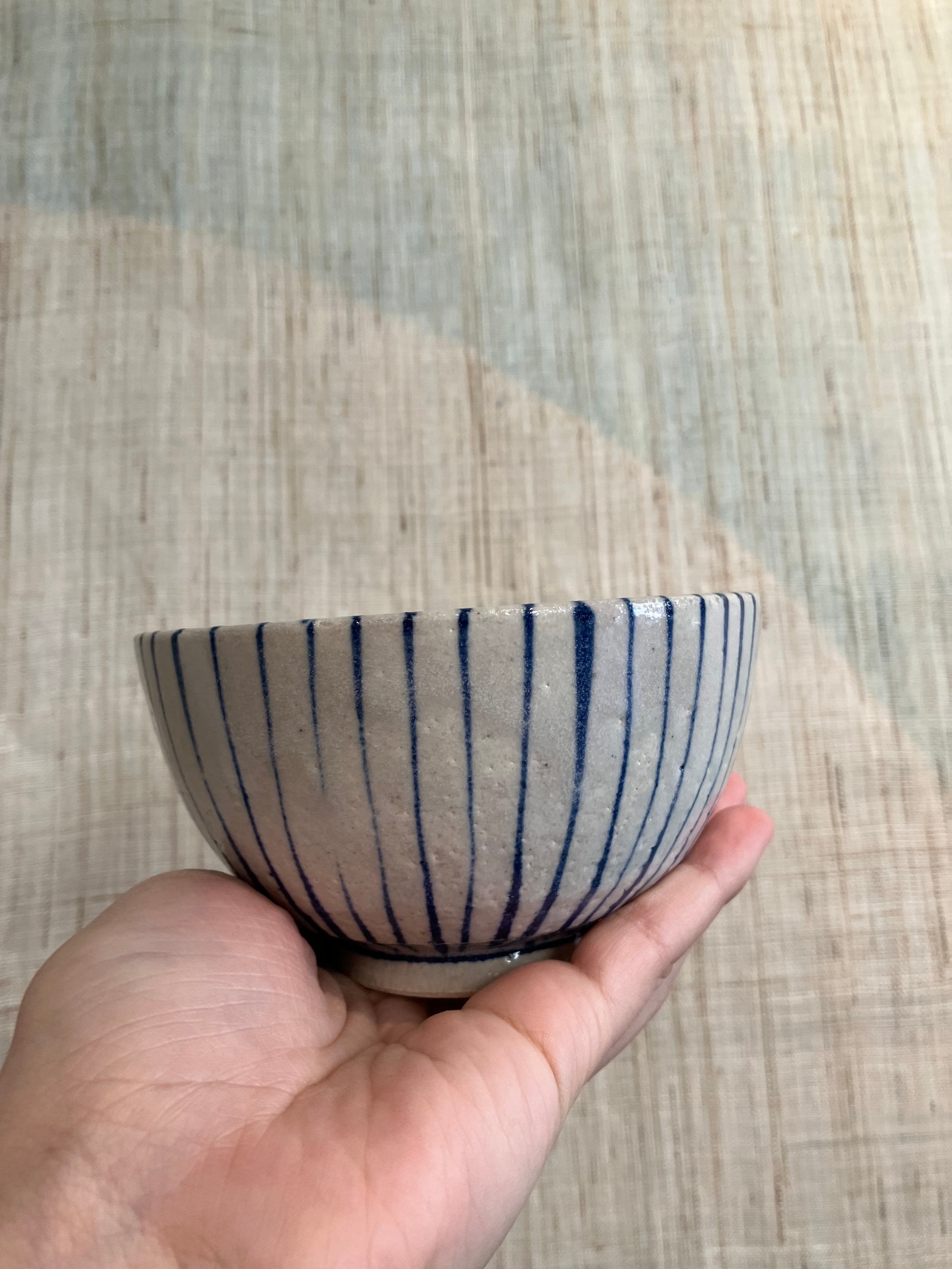 Small bowl with beige glaze and blue stripes