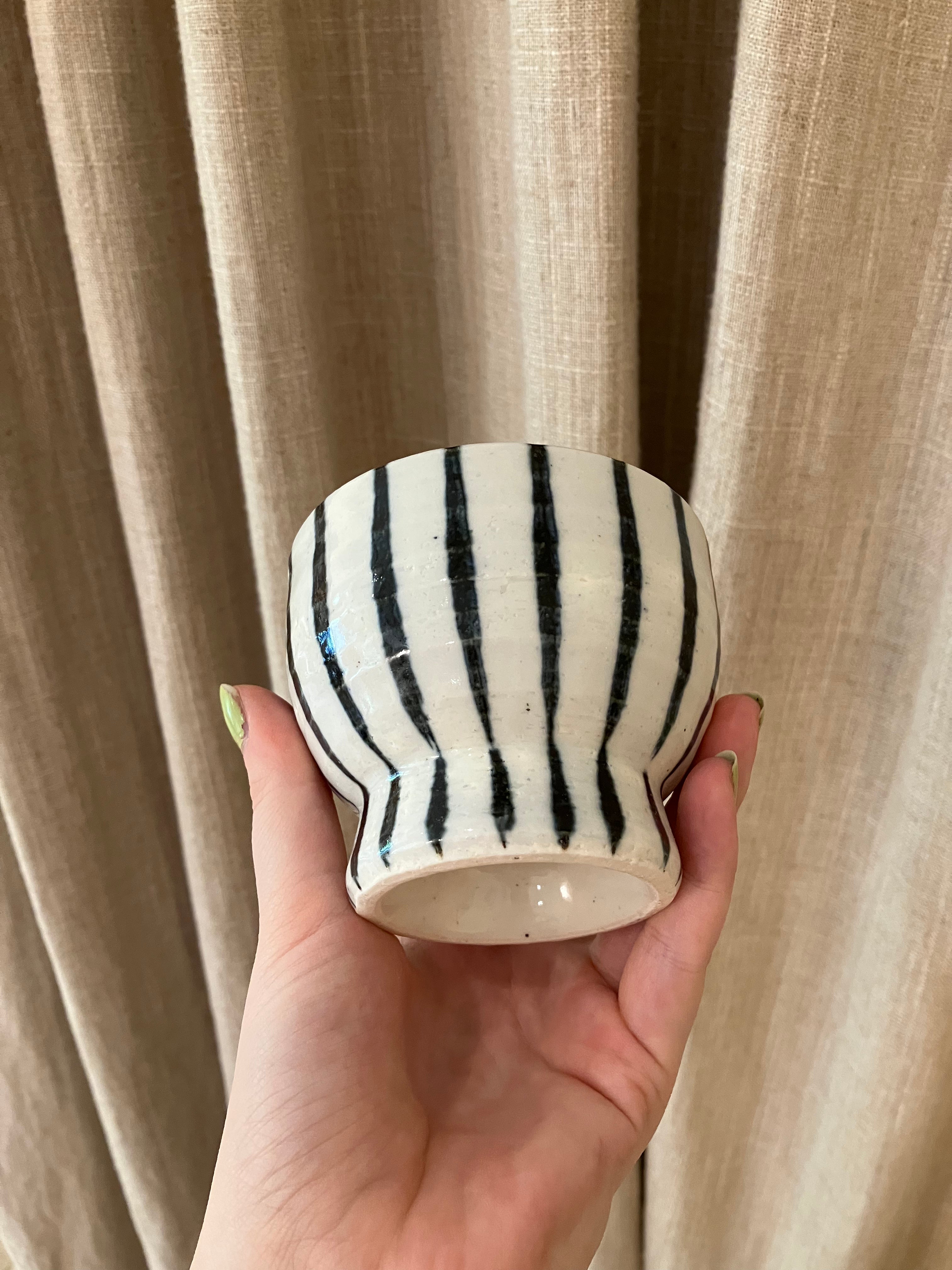 Handmade ceramic cup on foot with dark blue stripes