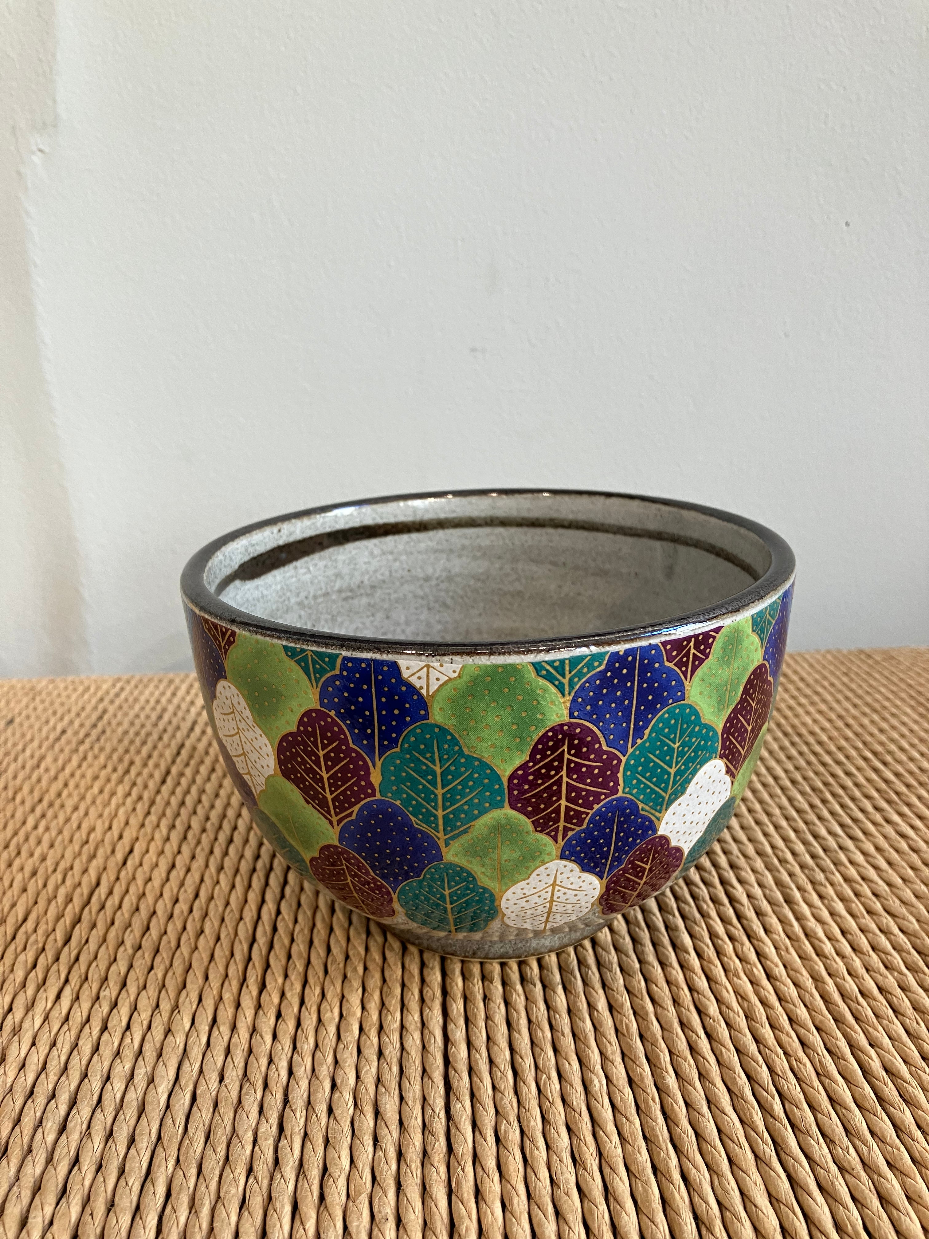 Hand painted bowl with a pattern of different colored leaves and gold dots