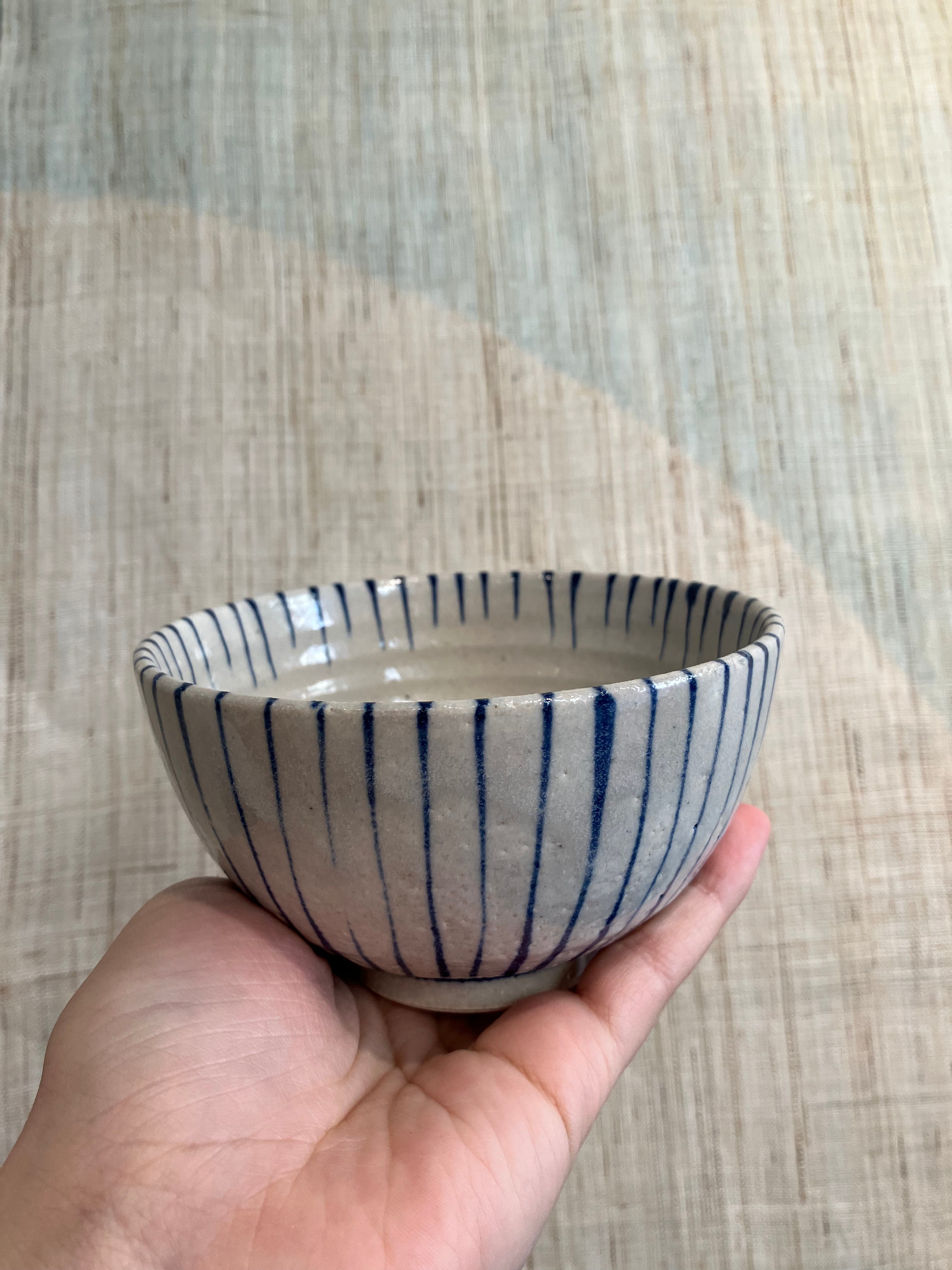 Small bowl with beige glaze and blue stripes