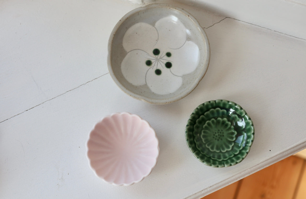 Small gray bowl with white flower and green dots