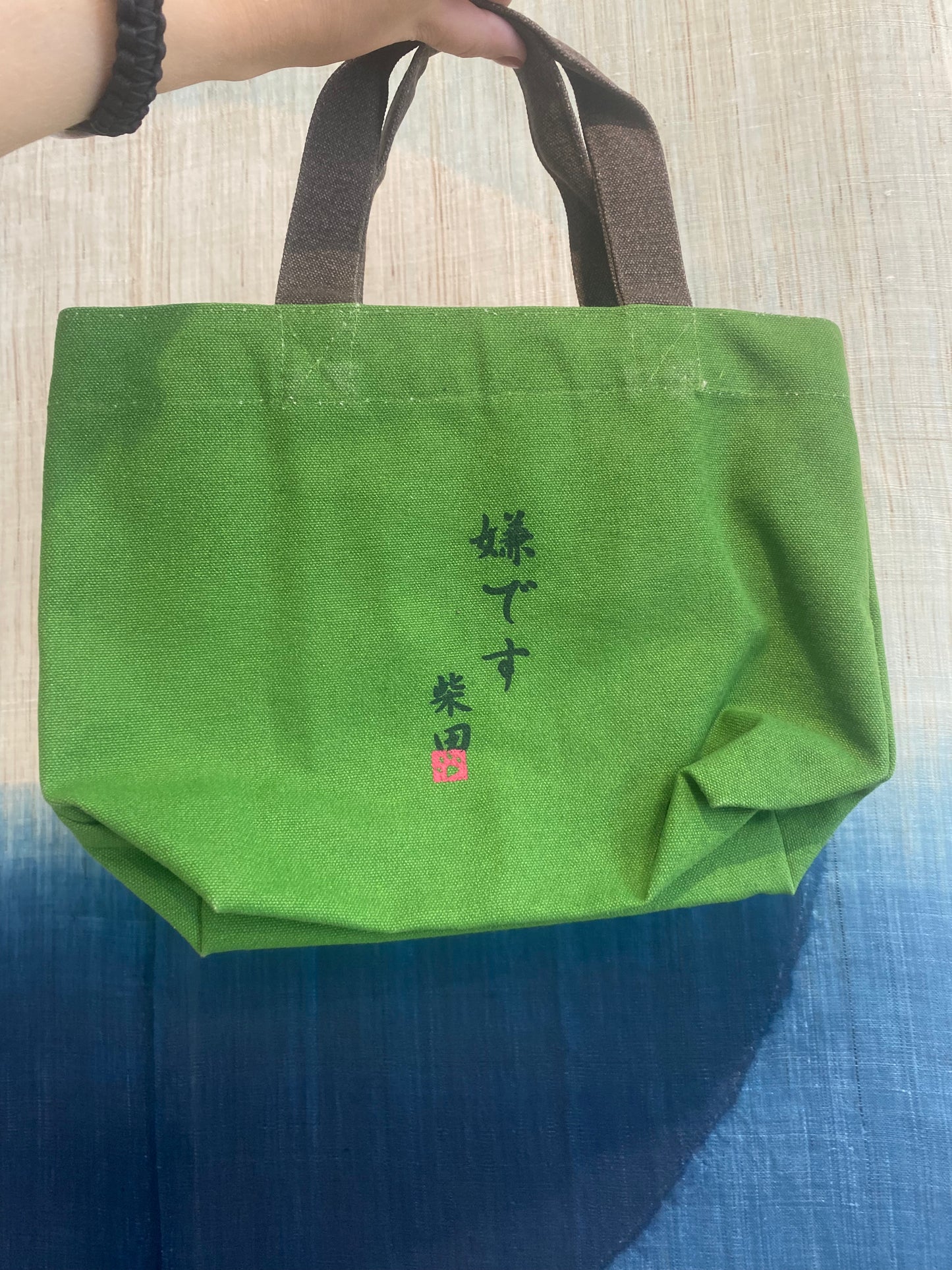 Lille grøn taske med stædig shiba, der trækker i snor