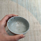 Lille skål med blågrå glasur og brune prikker