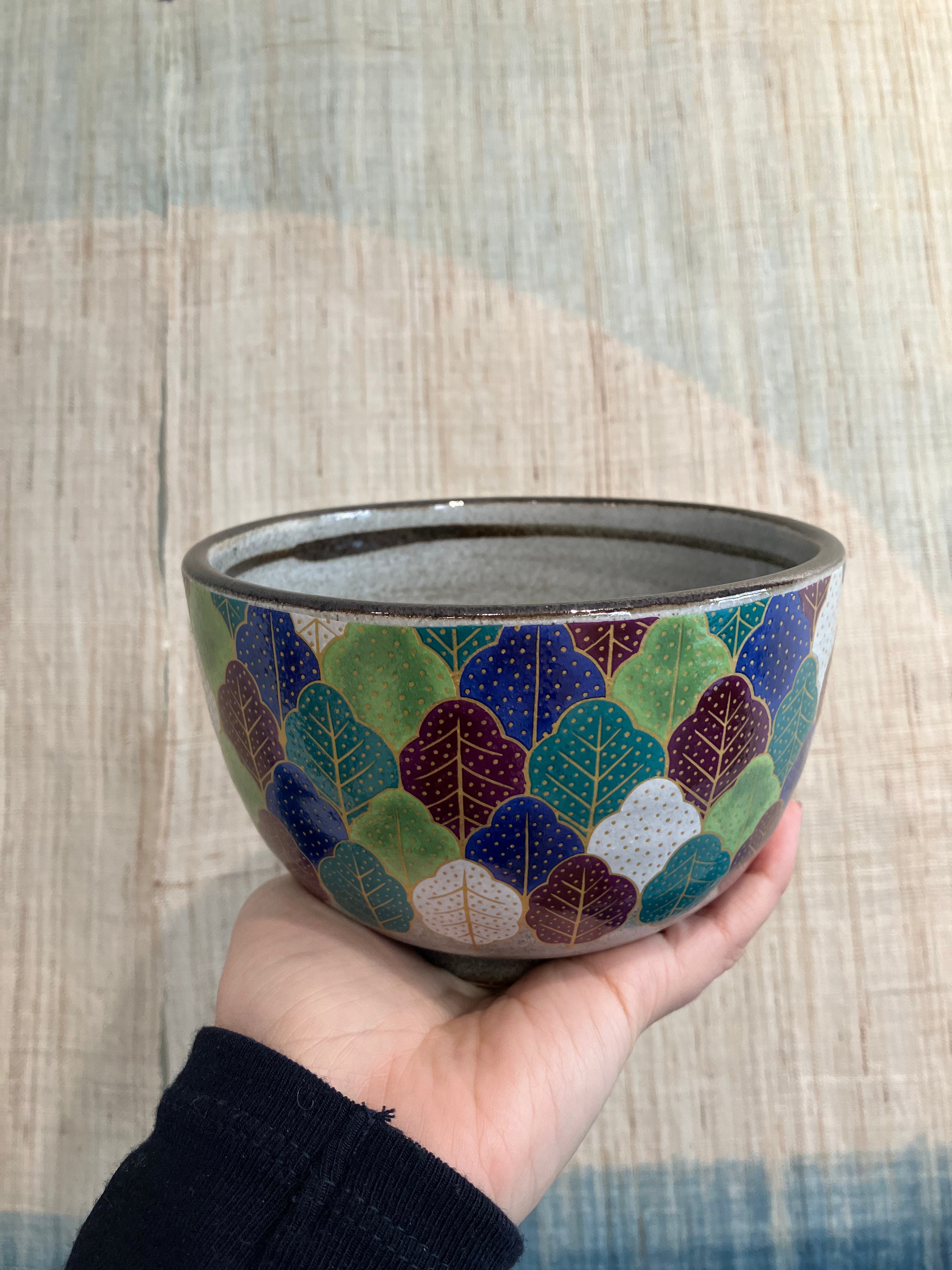 Hand painted bowl with a pattern of different colored leaves and gold dots