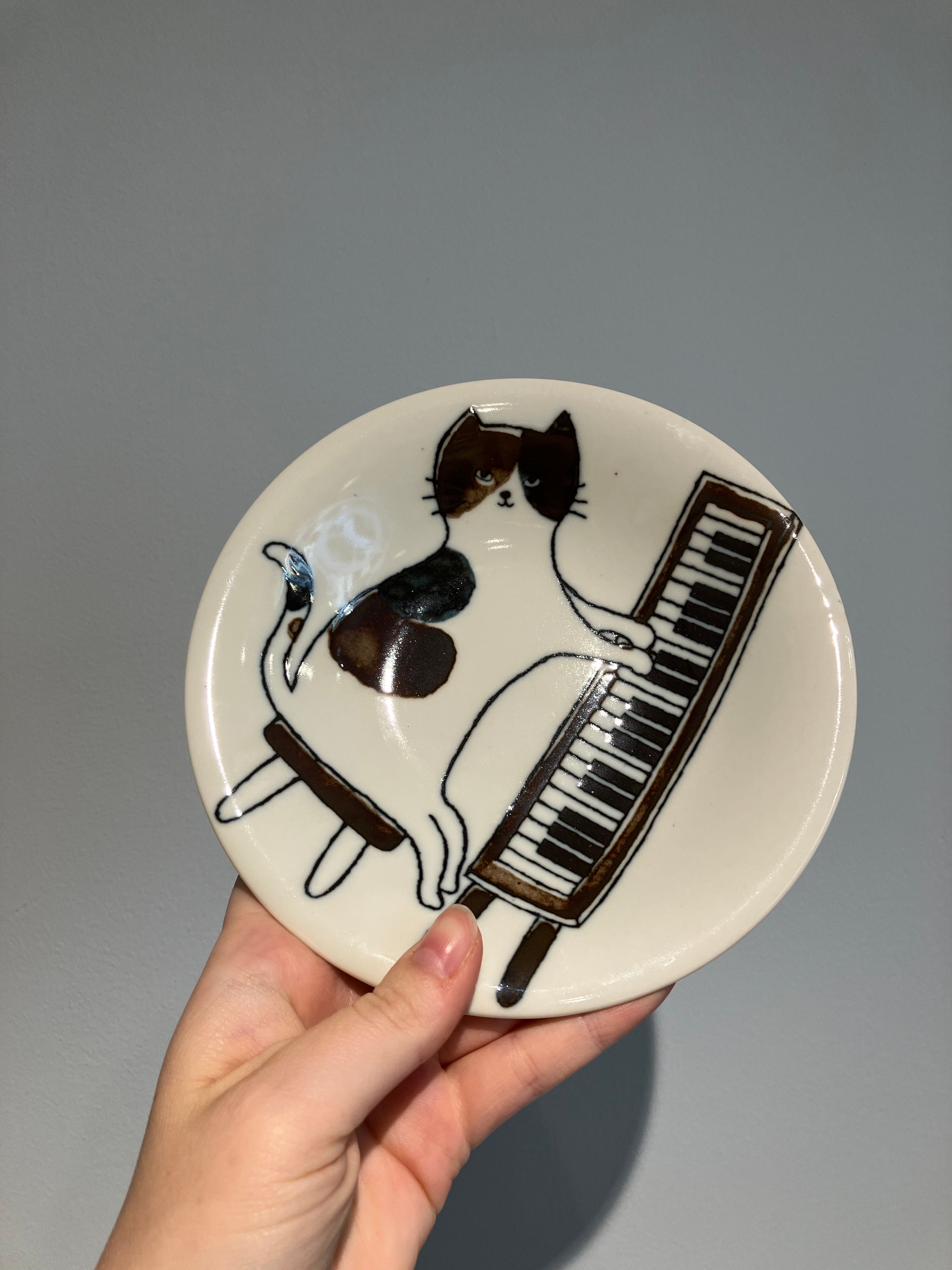 The plate with a cat playing the piano
