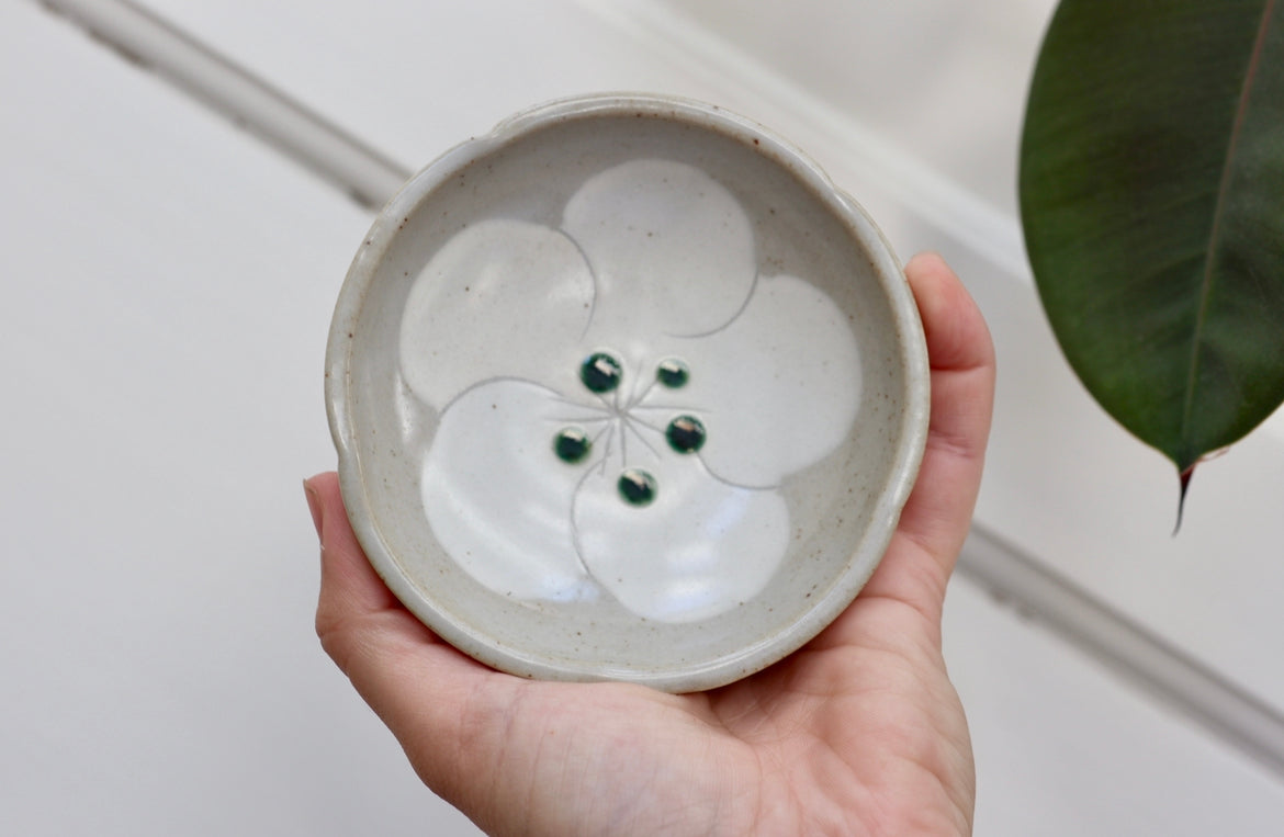 Small gray bowl with white flower and green dots