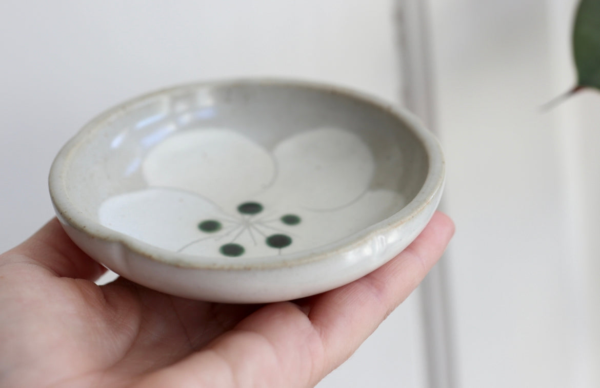 Small gray bowl with white flower and green dots