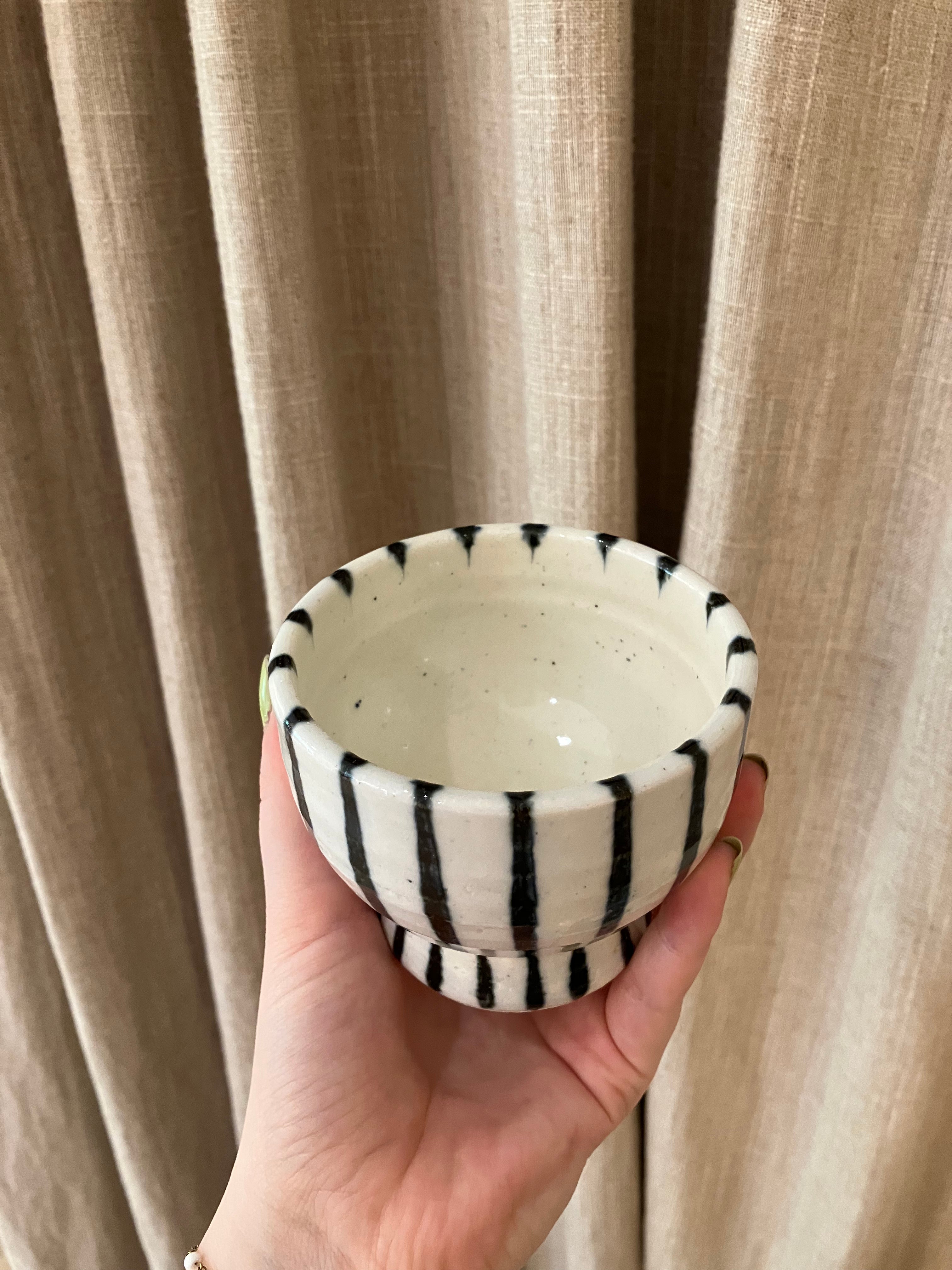 Handmade ceramic cup on foot with dark blue stripes