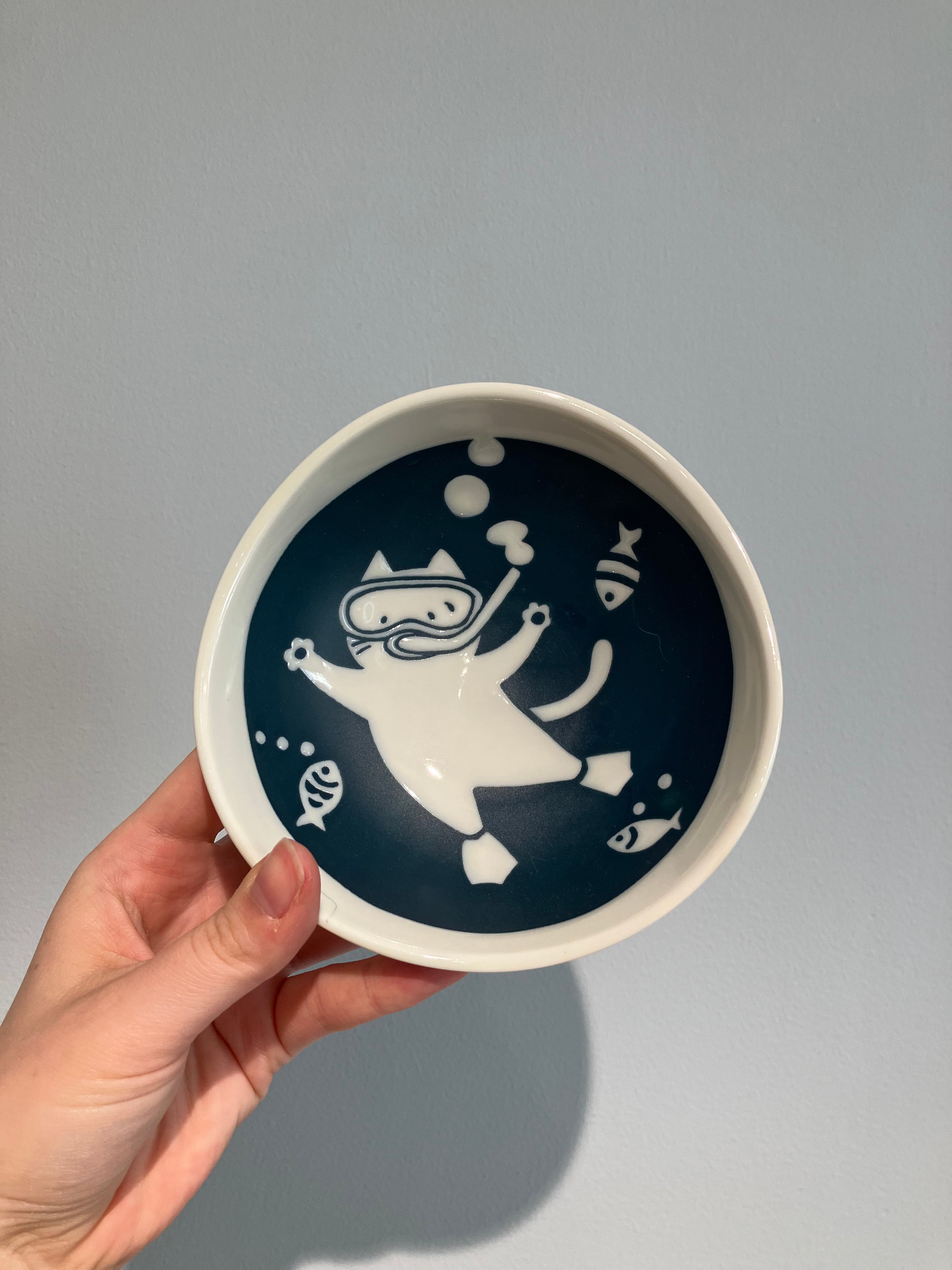 Bowl with cat diving