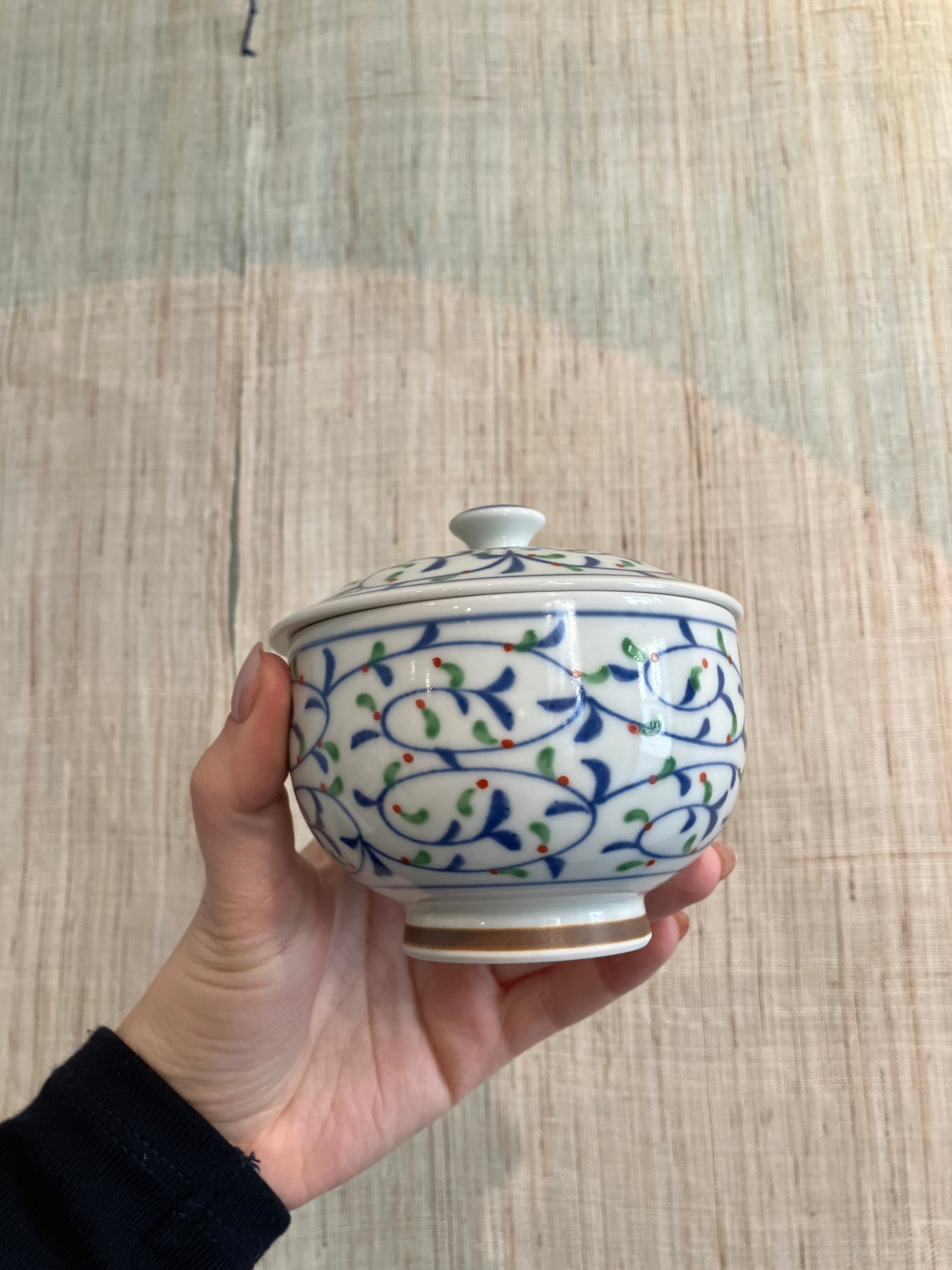 Lidded jar with pattern of leaves in blue, green and red