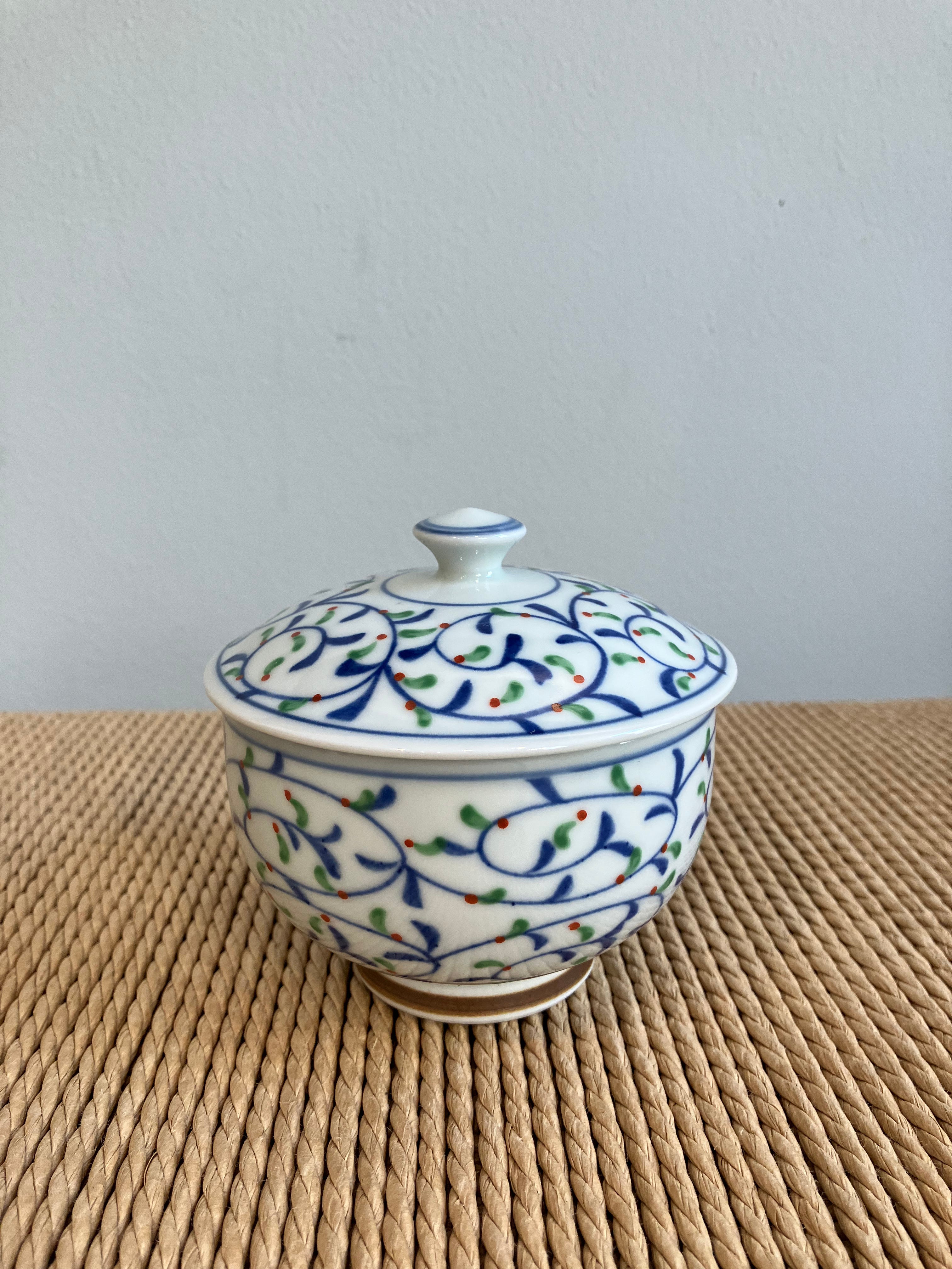 Lidded jar with pattern of leaves in blue, green and red