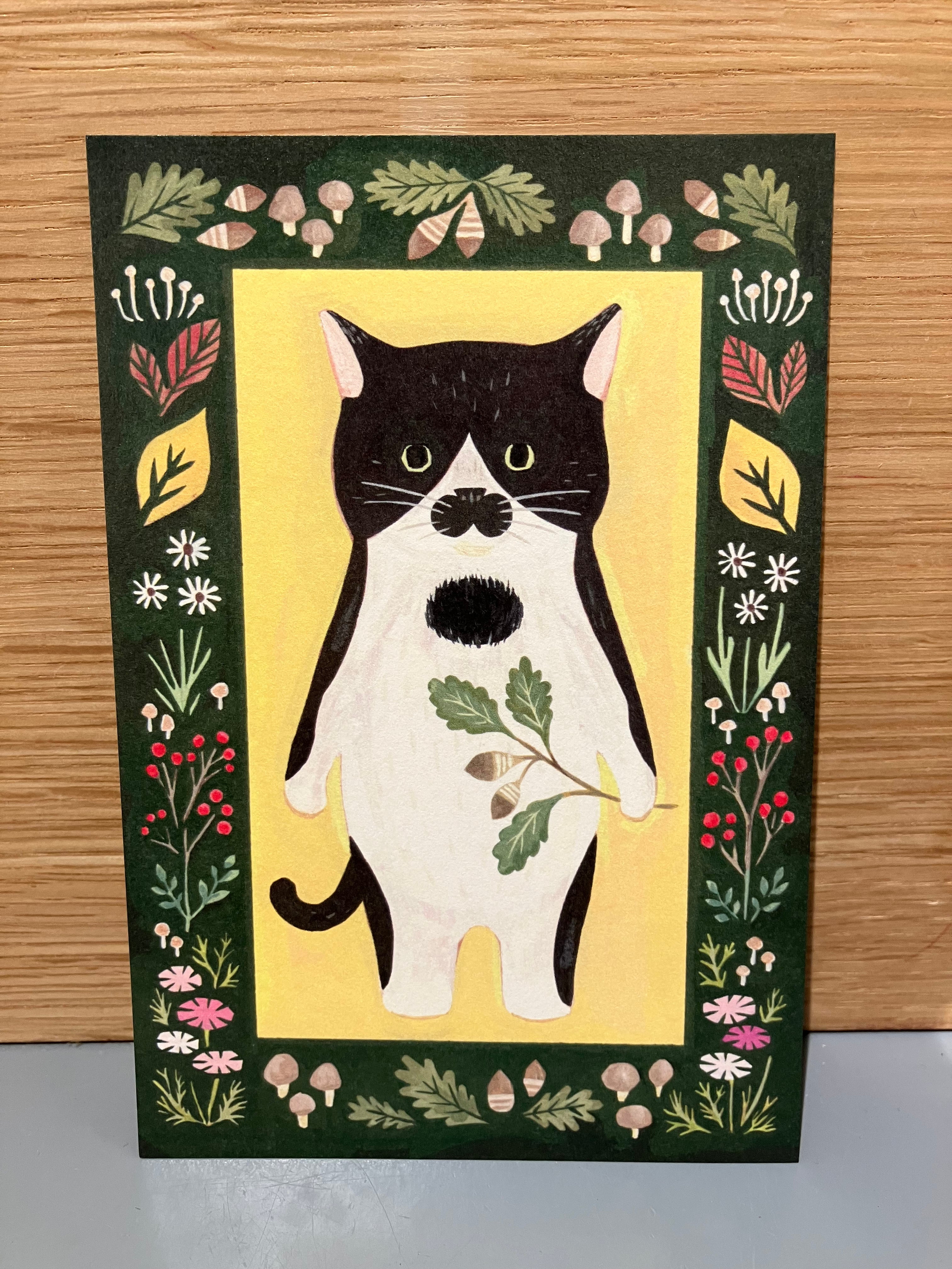 Japanese card with white and black cat holding a twig