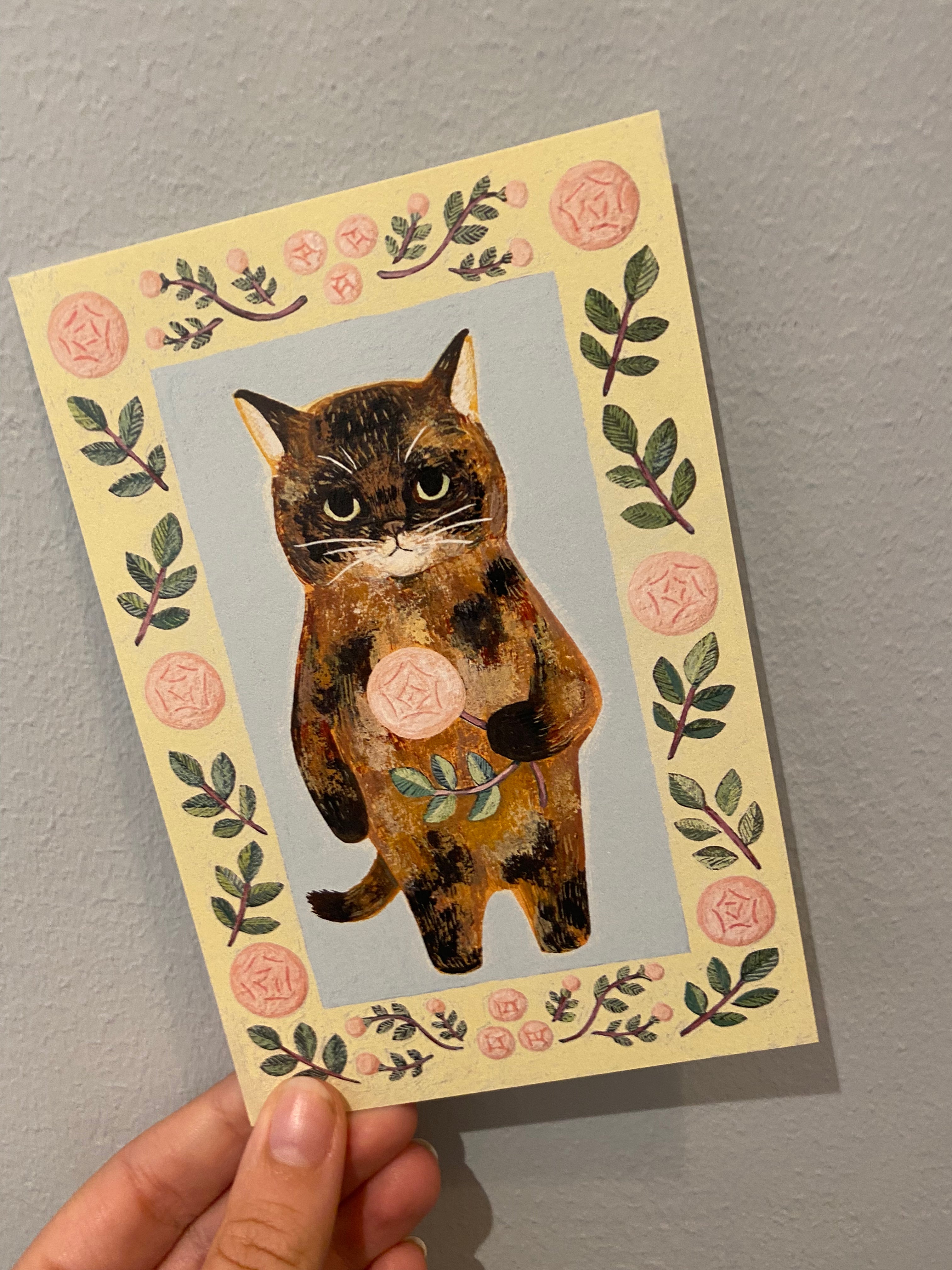Yellow card with cat holding a rose