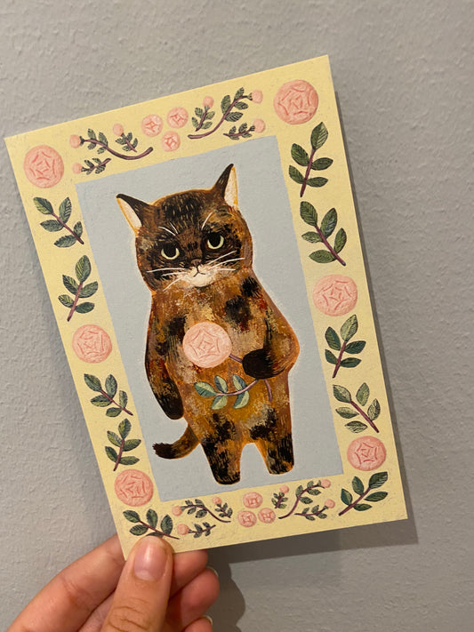 Gult kort med kat der holder en rose