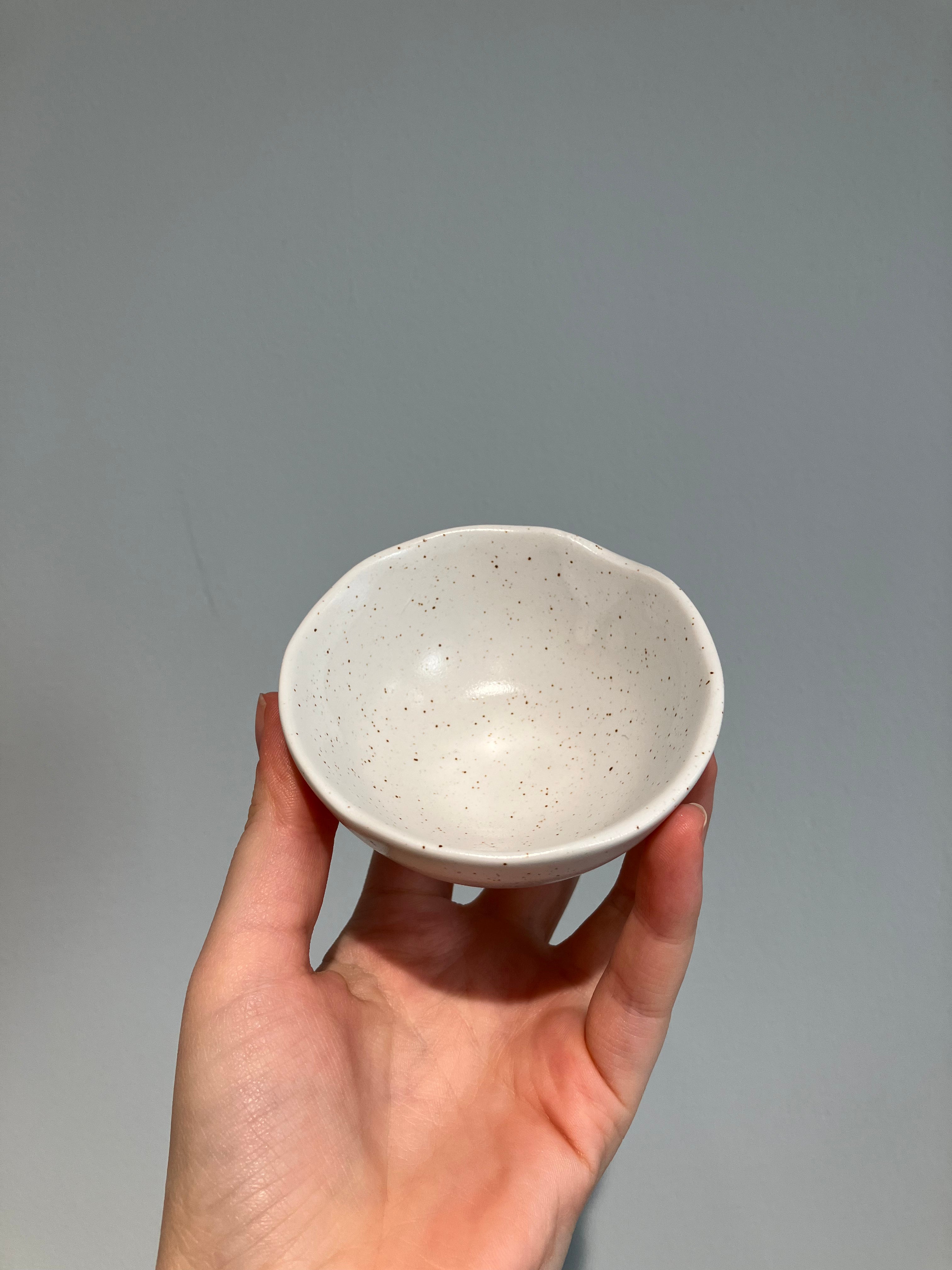 Small white organic bowl with brown dots and feet
