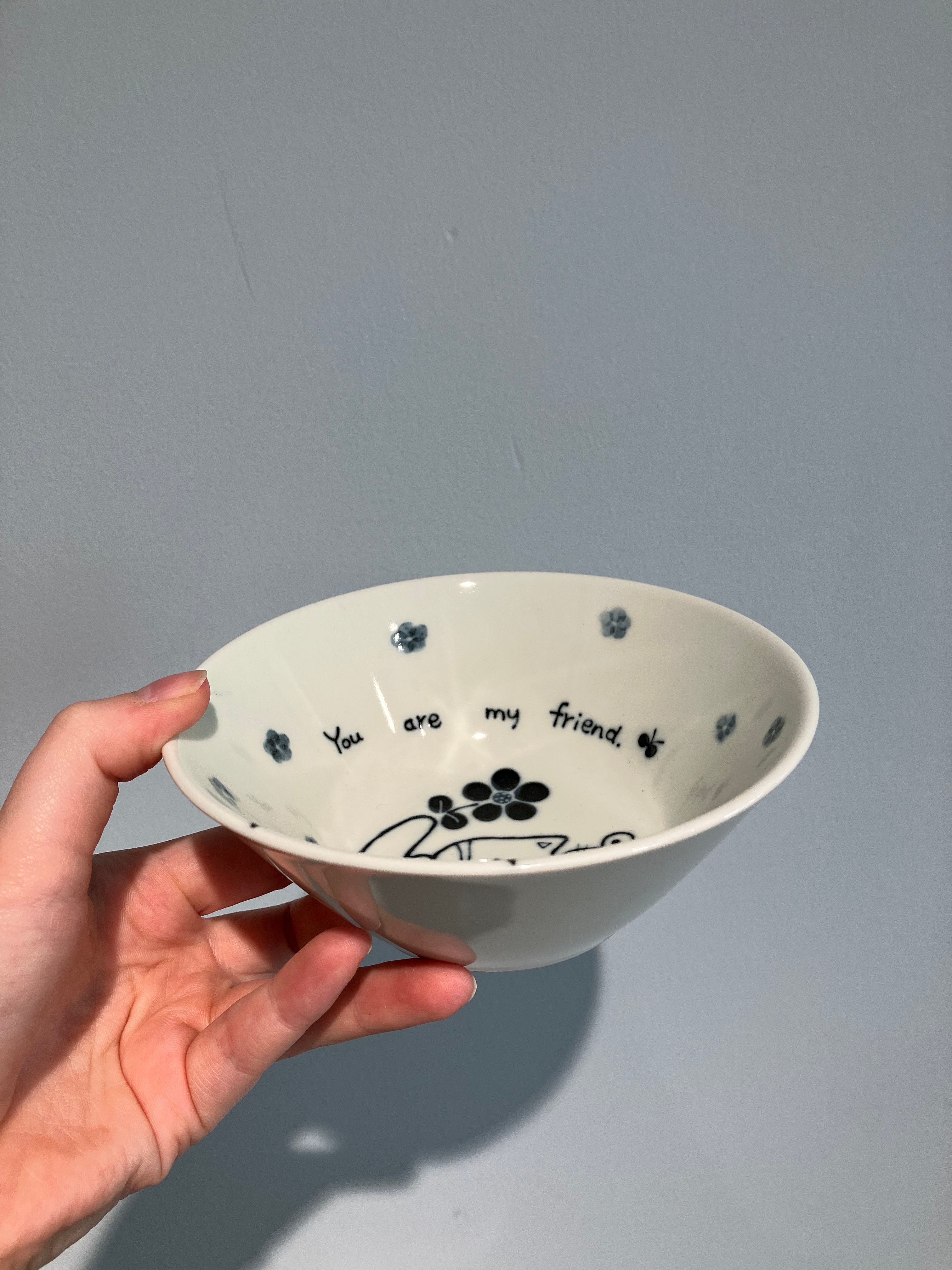 Bowl with a cat with a mouse on its head