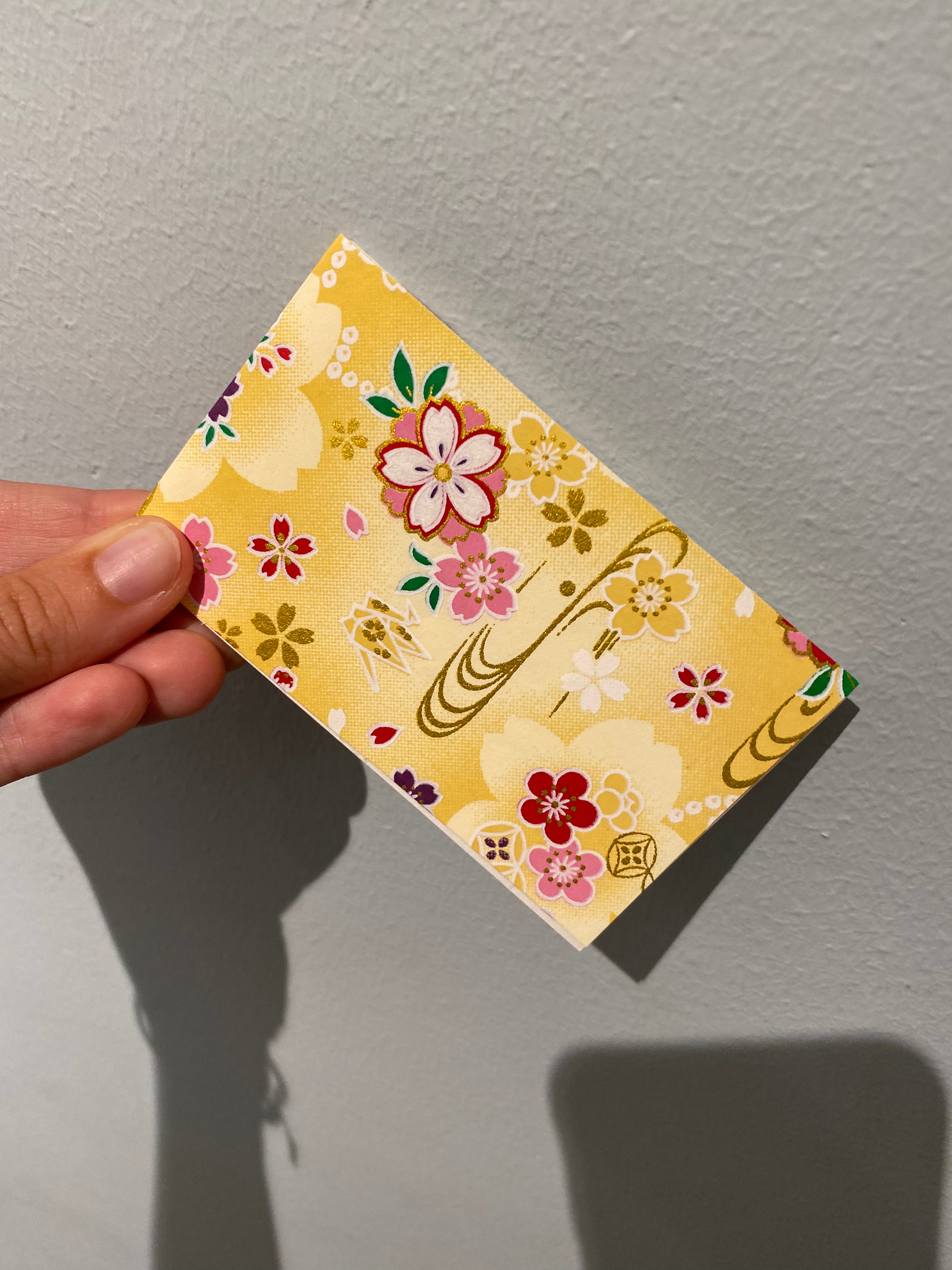 Lille gul notesblok med blomster