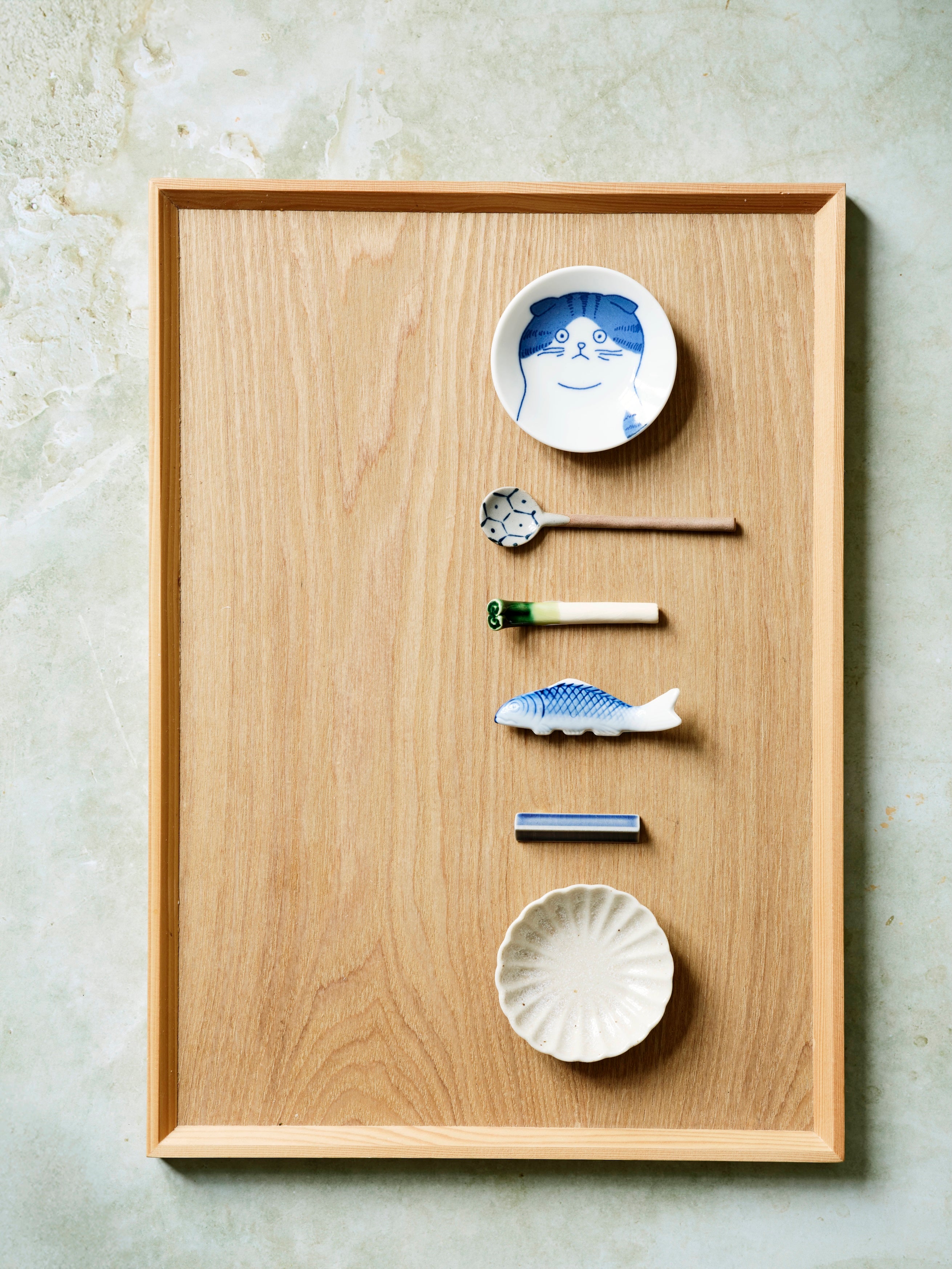 Japansk træbakke med små keramiske genstande i minimalistisk opstilling
